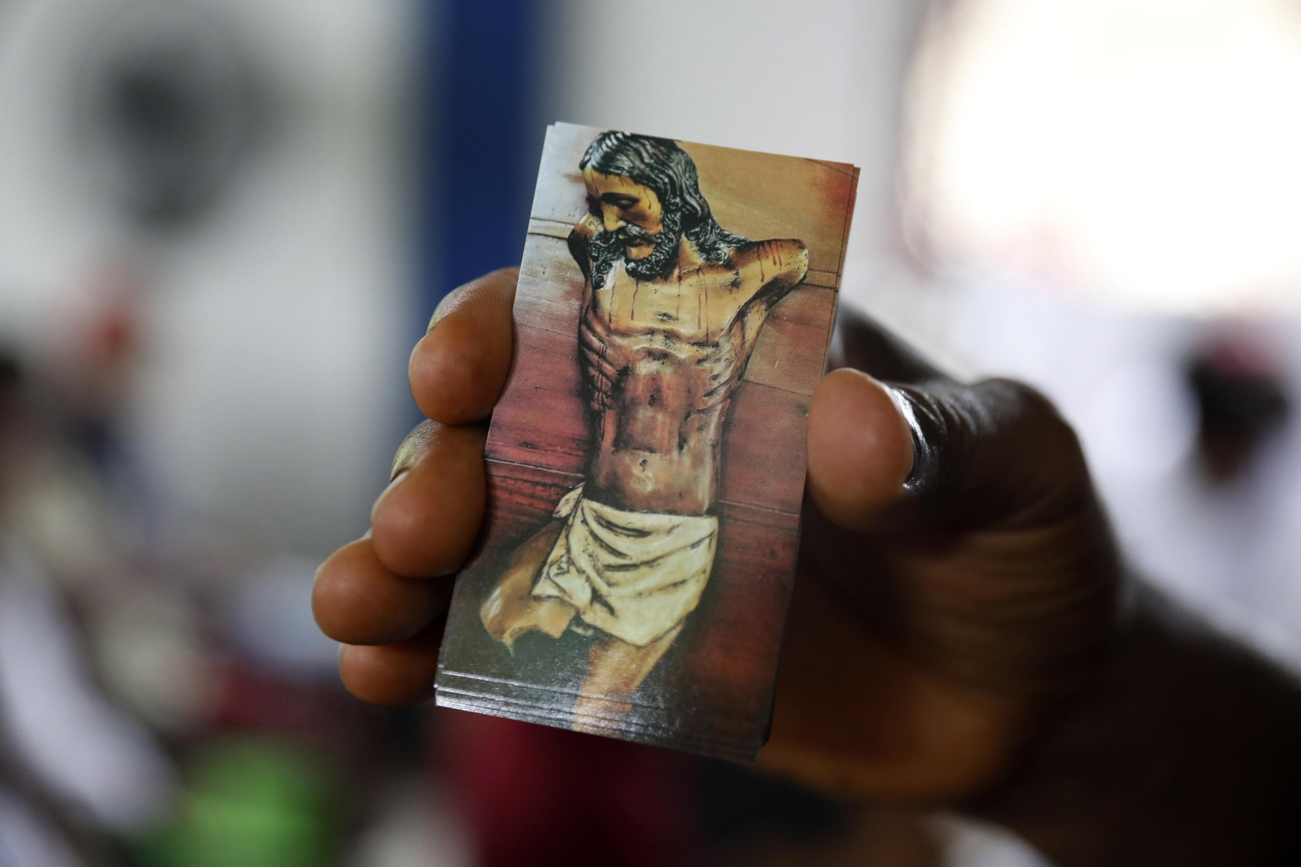 epa11315507 A man shows an image of the mutilated Christ of Bojayá during the commemoration of the 22nd anniversary of the Bojaya massacre, in Bojaya, Colombia, 02 May 2024. The Afro-descendant and indigenous communities of Bojaya, a municipality in the Colombian department of Choco, held a commemoration ceremony for the relatives and friends who died in the massacre that in which more than a hundred people were killed, 22 years ago.  EPA/Luis Eduardo Noriega A.