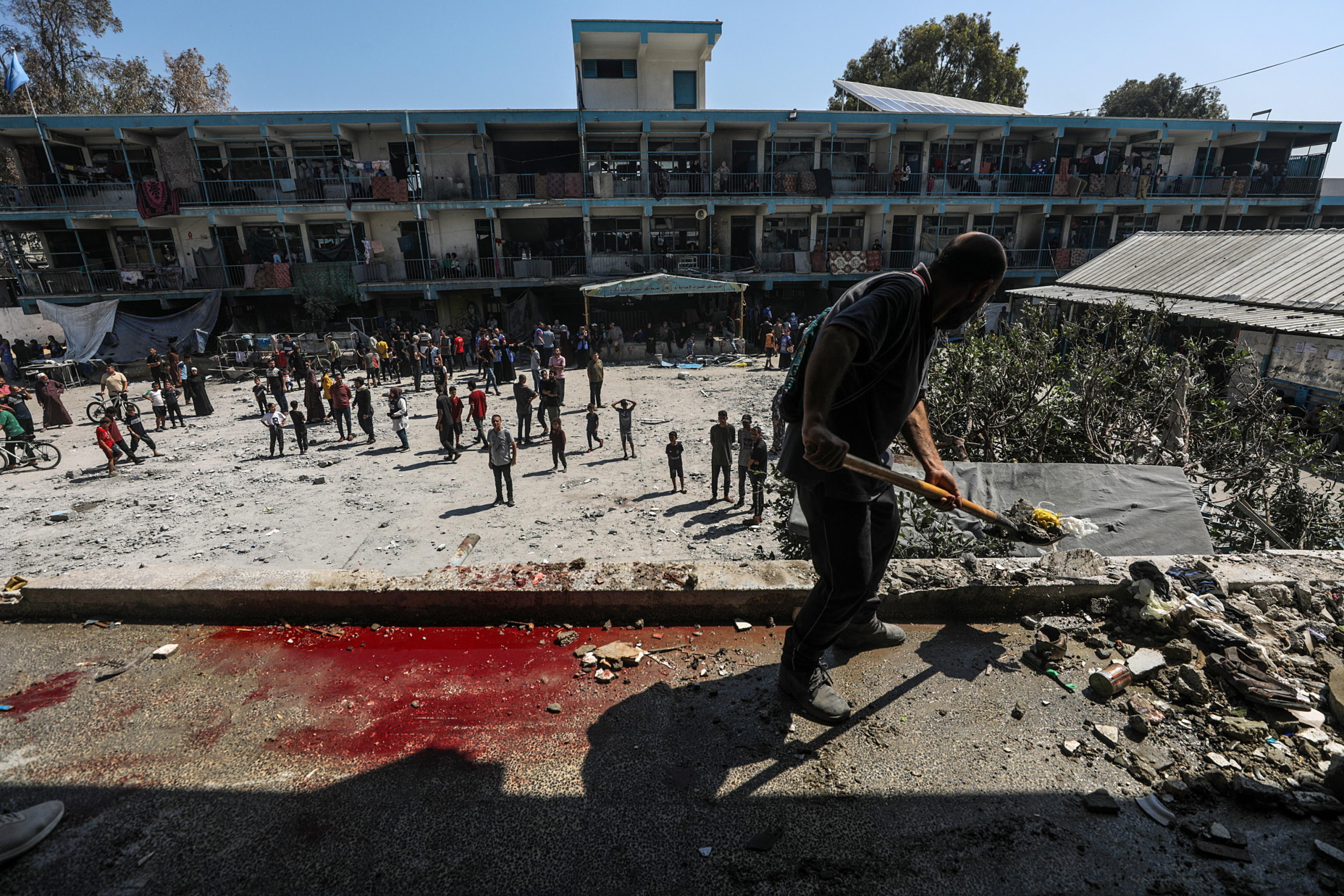 epa11392759 A Palestinian clears some rubble as others inspect a destroyed UNRWA school following an Israeli air strike in Al Nusairat refugee camp in the central Gaza Strip, 06 June 2024. According to the Palestinian News Agency Wafa, at least 32 people were killed and dozens others were injured on early 06 June following an Israeli strike on a UNRWA school sheltering displaced Palestinians, located in the Nuseirat refugee camp in the central Gaza strip. The Israeli army said that it had 