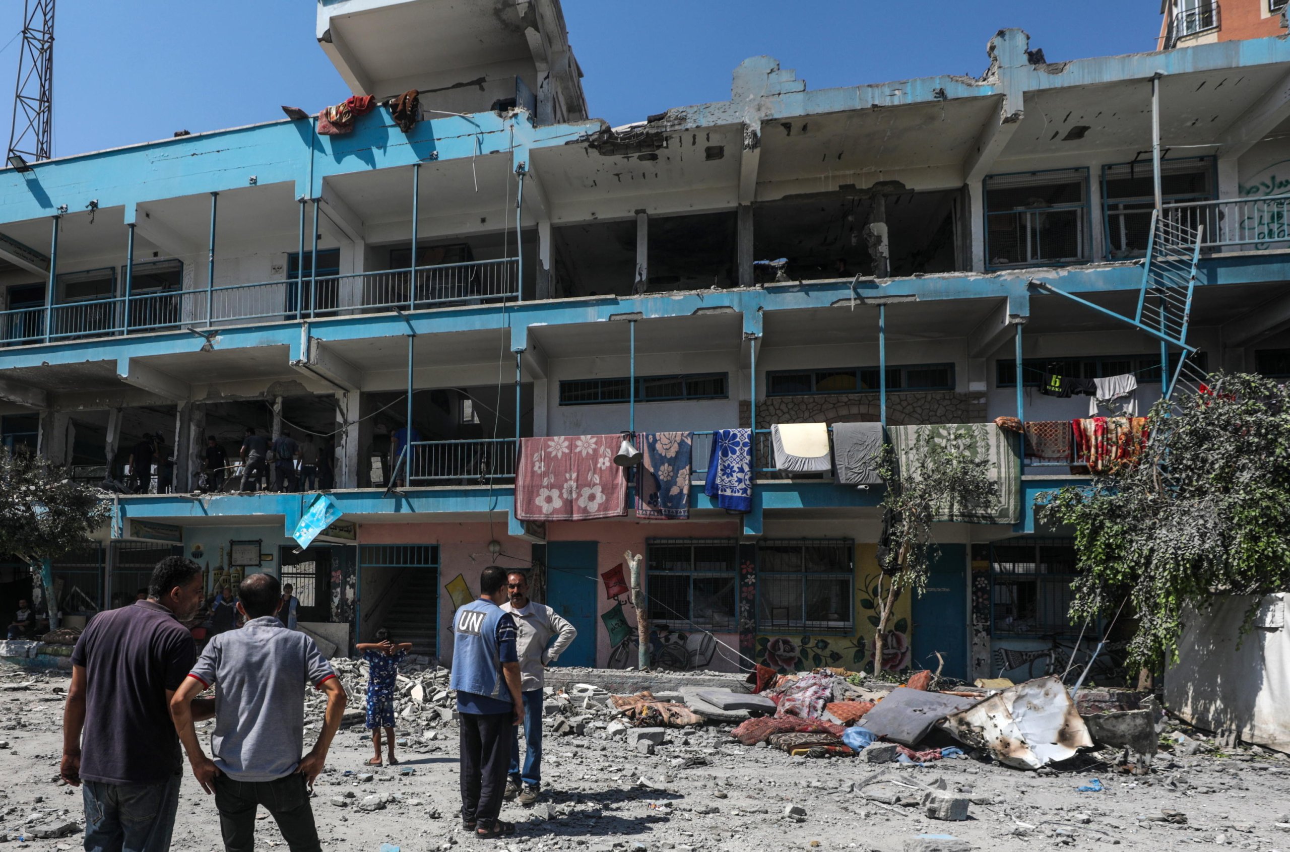 epa11392781 Palestinians inspect a destroyed UNRWA school following an Israeli air strike in Al Nusairat refugee camp in the central Gaza Strip, 06 June 2024. According to the Palestinian News Agency Wafa, at least 32 people were killed and dozens others were injured on early 06 June following an Israeli strike on a UNRWA school sheltering displaced Palestinians, located in the Nuseirat refugee camp in the central Gaza strip. The Israeli army said that it had 