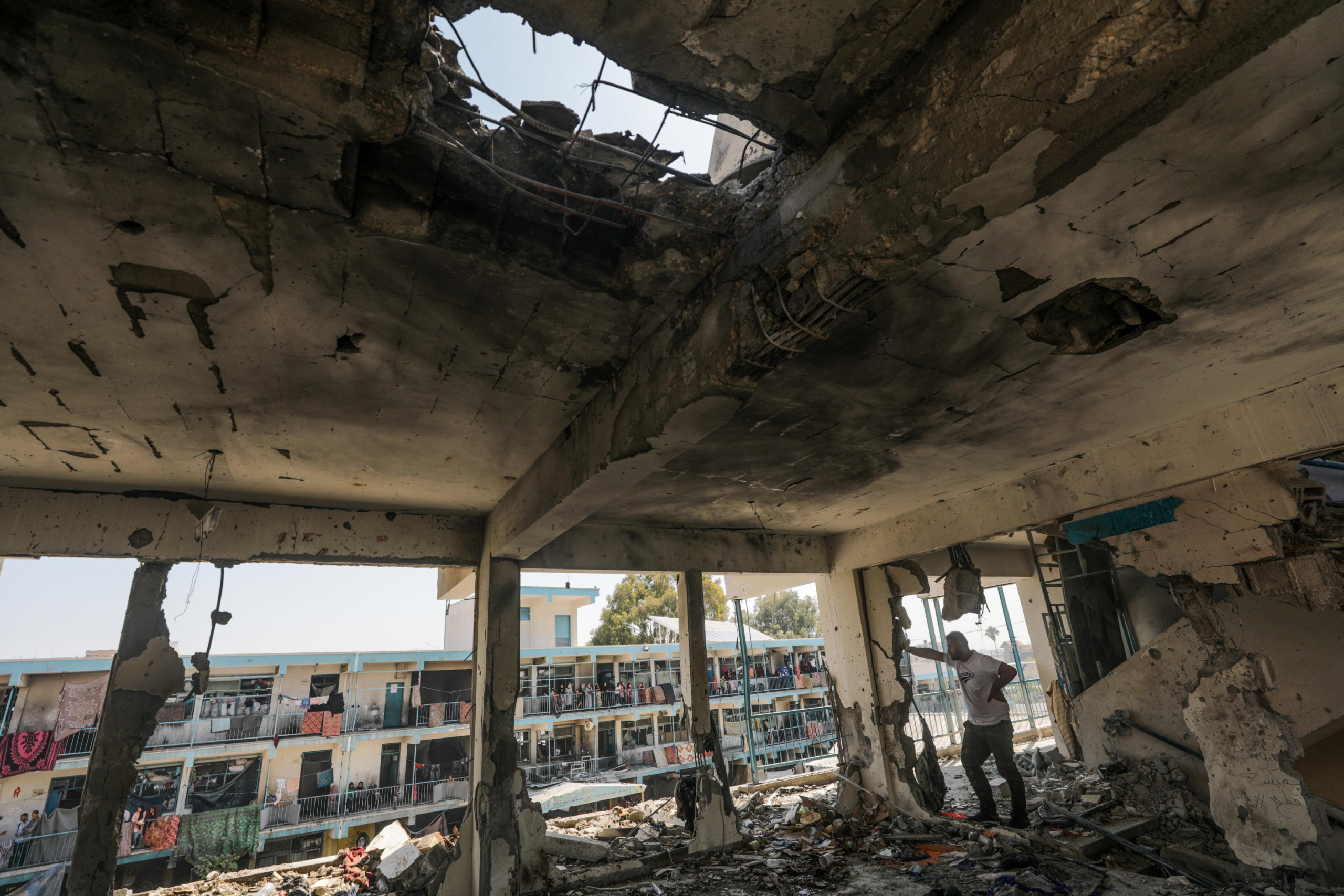 epa11392943 A  Palestinians looks at he damages at a destroyed UNRWA school following an Israeli air strike in Al Nusairat refugee camp in the central Gaza Strip, 06 June 2024. According to the Palestinian News Agency Wafa, at least 32 people  were killed and dozens others were injured on early 06 June following an Israeli strike on a UNRWA school sheltering displaced Palestinians, located in the Nuseirat refugee camp in the central Gaza strip. The Israeli army said that it had 