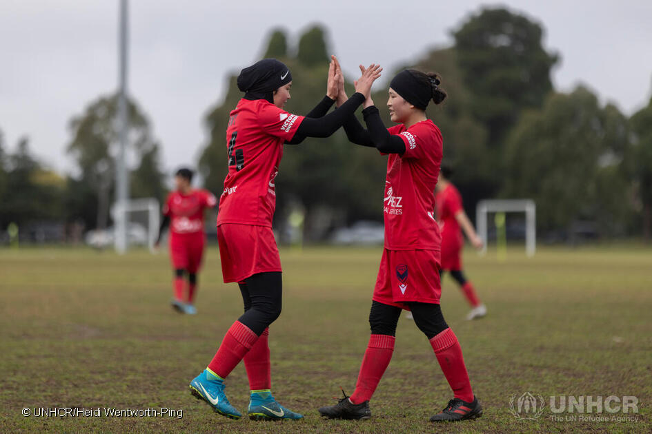 Adiba, left, celebrates with a teammate of the Afghan Women's Football Team after winning a match at Princess Park, in Carlton, Melbourne, Australia. Evacuated from Afghanistan after the de facto authorities came to power, the team, which is sponsored by the Australian professional club Melbourne Victory, now competes in the Victoria state league. ; Since 2021, some 1.6 million people have fled Afghanistan, mainly to neighbouring countries. Another 3.2 million remain internally displaced inside the country. After the de facto authorities came to power in August 2021, the Australian government granted emergency visas to evacuate the Afghan Women’s Football Team, including 38 women players, as well as their family members, to Australia, as they were no longer safe in their home country. 

High Commissioner Filippo Grandi met the Afghan Women’s Football Team in Australia during a visit in April 2023, where he commended “the transformative power of sport for people displaced by war and conflict”.