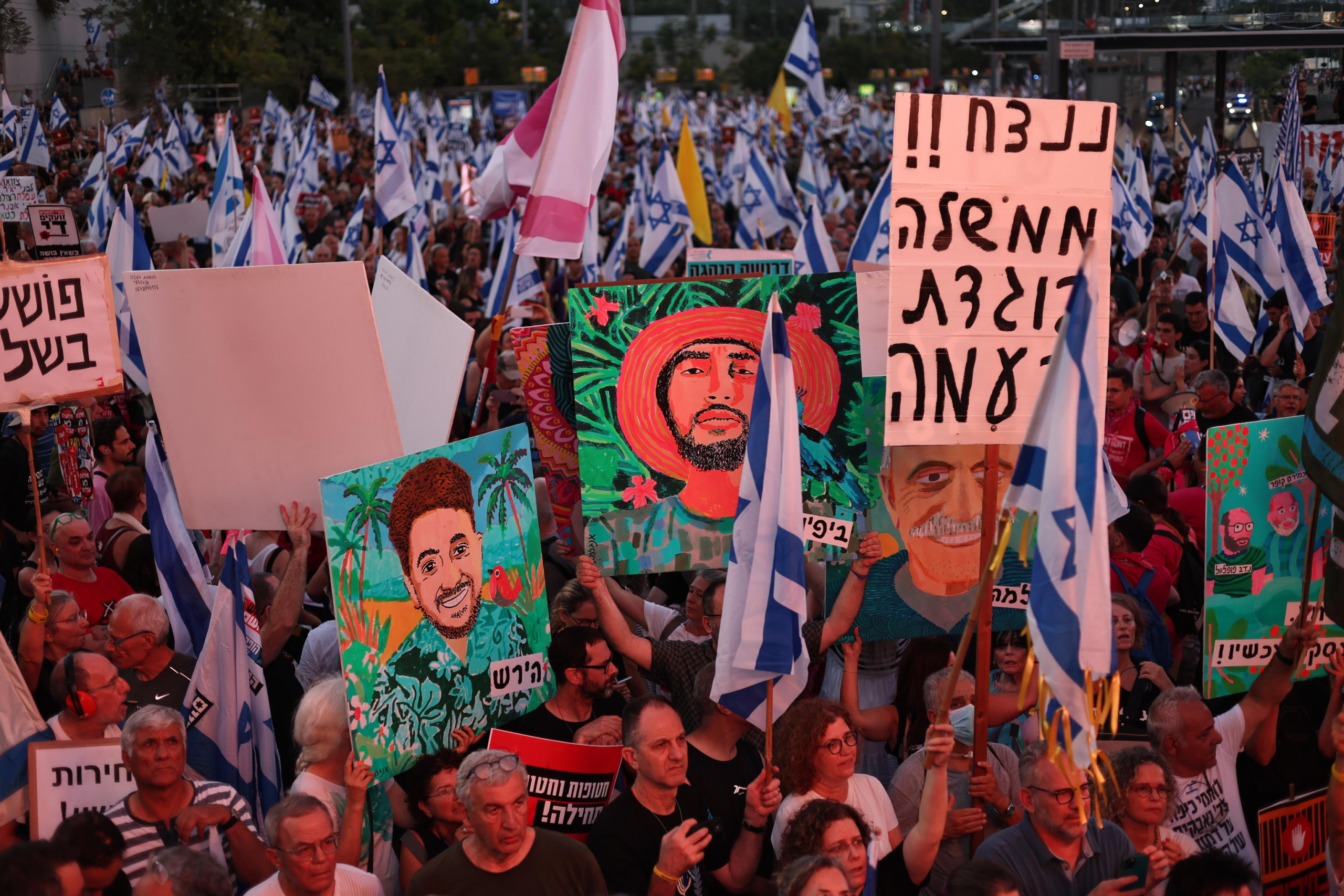 epa11445646 Israeli protesters hold up banners during an anti-government demonstration calling for immediate elections, the resignation of Prime Minister Netanyahu's government and the release of the hostages held in Gaza, near the Kirya military headquarters in Tel Aviv, Israel, 29 June 2024.  EPA/ATEF SAFADI