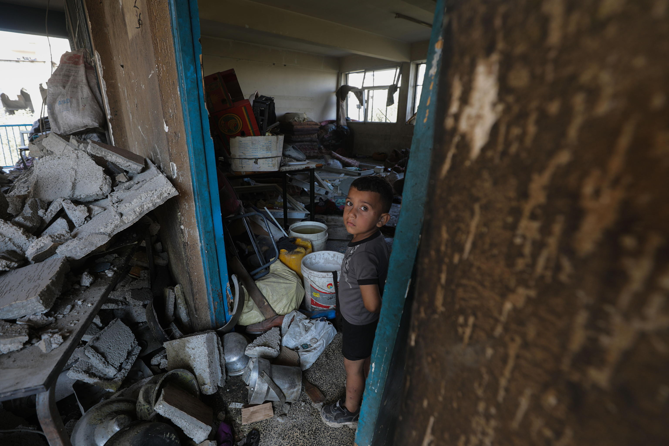 epa11478206 A Palestinian boy looks on while standing among debris inside a damaged UNRWA school following an Israeli air strike in Al Nuseirat refugee camp, central Gaza Strip, 14 July 2024. At least 12 people were killed following an Israeli air strike in the camp, according to the Palestinian Ministry of Health. The Israeli military stated on 14 July, that the Israeli Air Force (IAF) struck the area of UNRWA's Abu Oraiban School School building in Nuseirat, claiming that the location served as a 'hideout and operational infrastructure' to direct and carry attacks against Israeli troops operating in the Gaza Strip. More than 38,000 Palestinians and over 1,400 Israelis have been killed, according to the Palestinian Health Ministry and the Israel Defense Forces (IDF), since Hamas militants launched an attack against Israel from the Gaza Strip on 07 October 2023, and the Israeli operations in Gaza and the West Bank which followed it.  EPA/MOHAMMED SABER