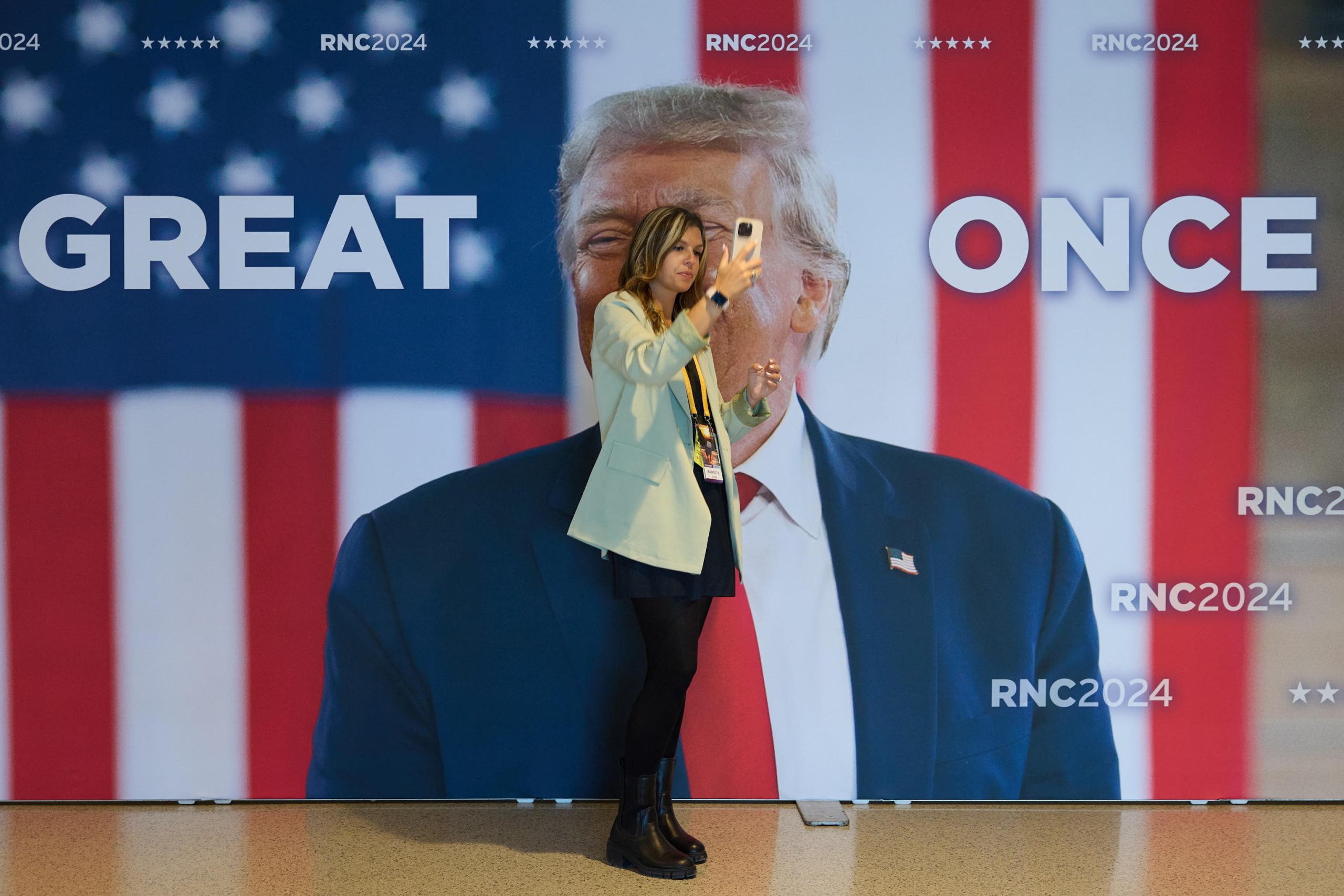 epa11486332 A woman takes a selfie with a poster of Republican presidential nominee and former President Donald Trump on the fourth day of the Republican National Convention (RNC) at Fiserv Forum in Milwaukee, Wisconsin, USA, 18 July 2024. The convention comes days after a 20-year-old Pennsylvania man attempted to assassinate former president and current Republican presidential nominee Donald Trump. The 2024 Republican National Convention is being held 15 to 18 July 2024 in which delegates of the United States Republican Party select the party's nominees for president and vice president in the 2024 United States presidential election.  EPA/ALLISON DINNER