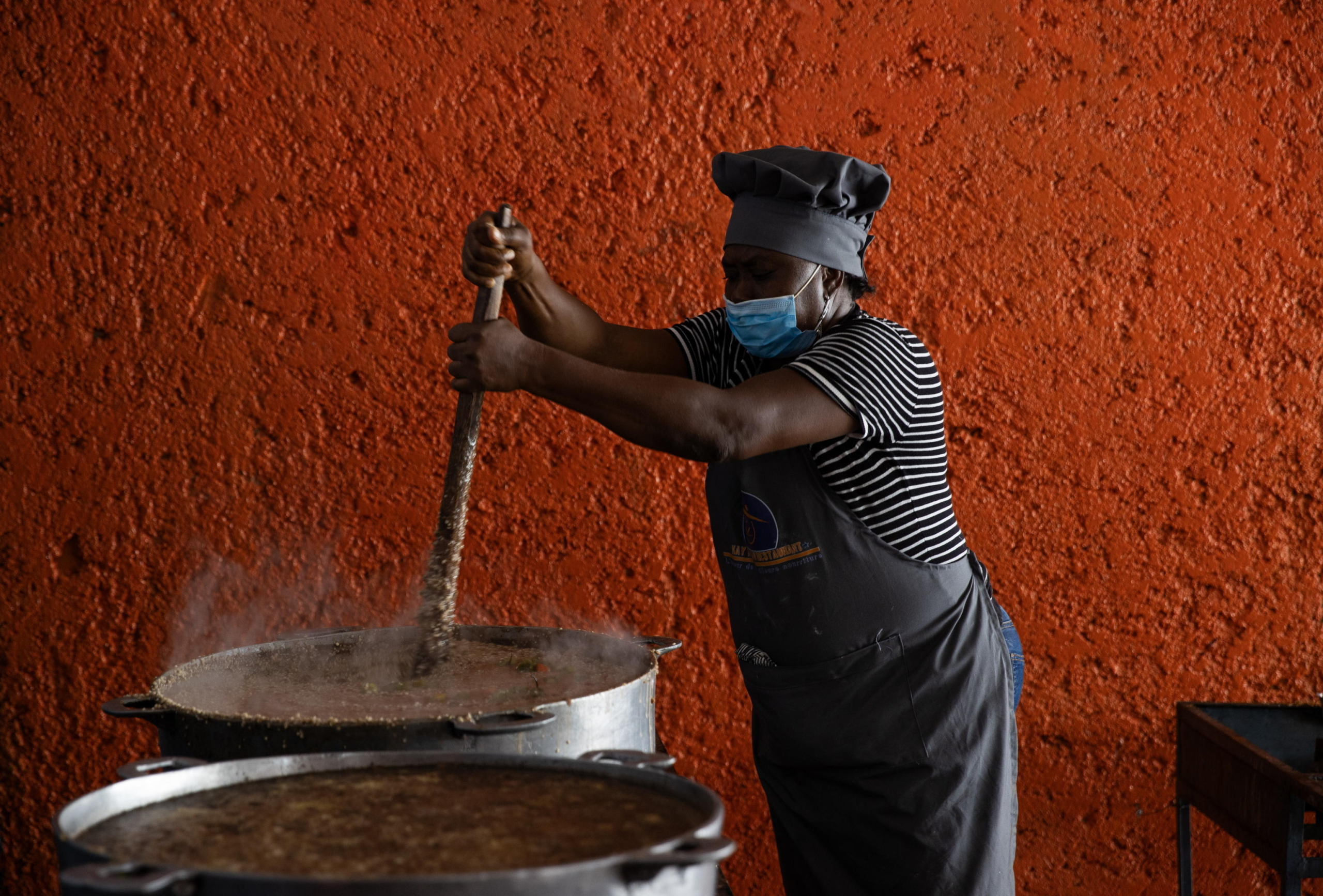 epa11396672 World Food Program (WFP) staff member prepares food for refugees in Port-au-Prince, Haiti, 05 June 2024 (Issued 07 June 2024). In the central kitchen of the World Food Program (WFP) in the Haitian capital of Port-au-Prince, employees work against a clock to combat hunger preparing meals for delivery to camps, where thousands of families await food, which is sometimes the only meal of the day for many of them. One such shelter is the Isidor Jean Louis College, situated in the center of Port-au-Prince hosting 600 refugees for several months following the abandonment of their homes due to the violence perpetrated by armed gangs.  EPA/ORLANDO BARRIA