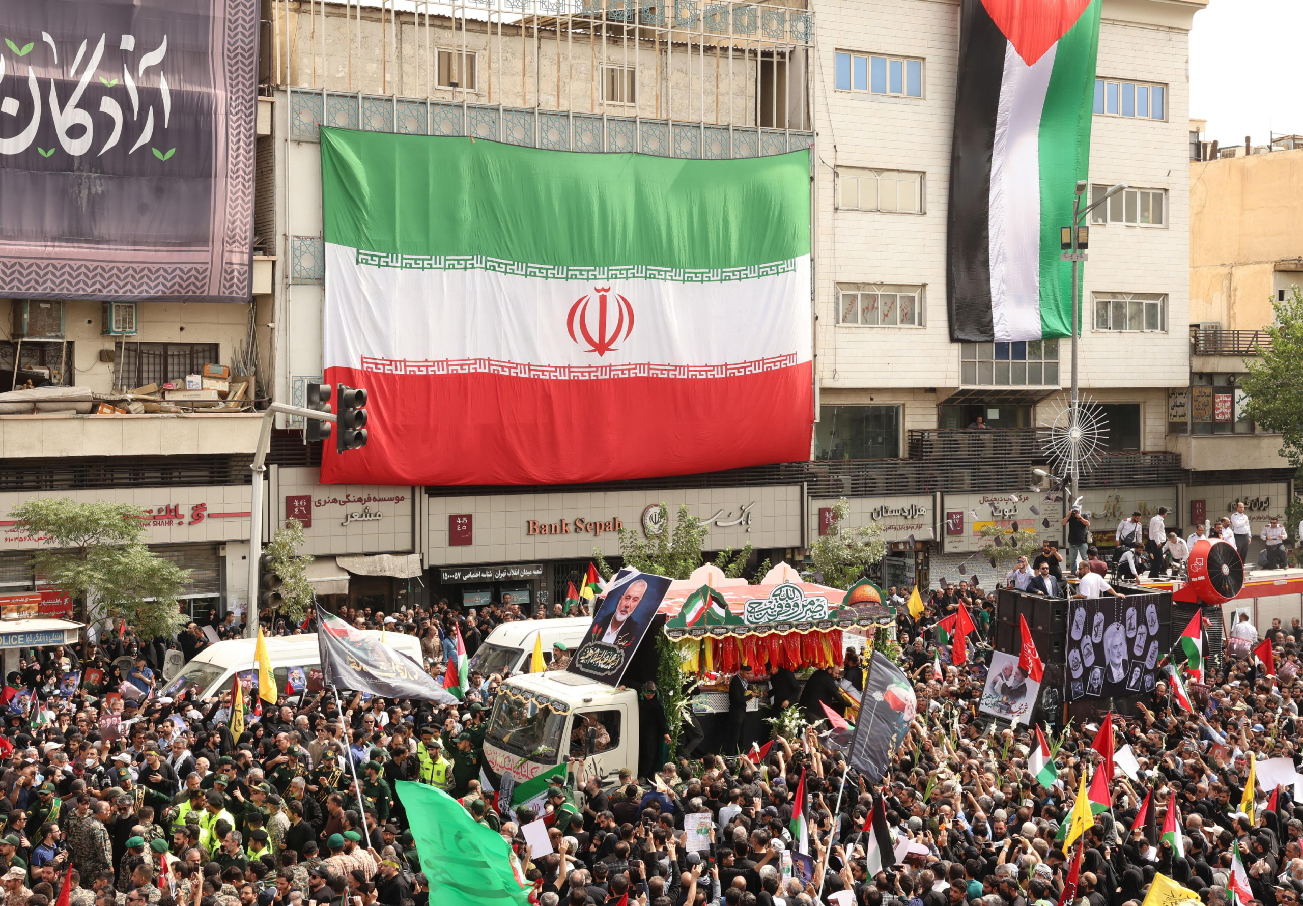 epaselect epa11514233 People gather as the coffins of Hamas late political leader Ismail Haniyeh and his bodyguard are carried on the back of a truck during a funeral procession in Tehran, Iran, 01 August 2024. Haniyeh and one of his bodyguards were targeted and killed in Tehran on 31 July 2024, the Iranian Revolutionary Guard Corps (IRGC) confirmed.  EPA/ABEDIN TAHERKENAREH