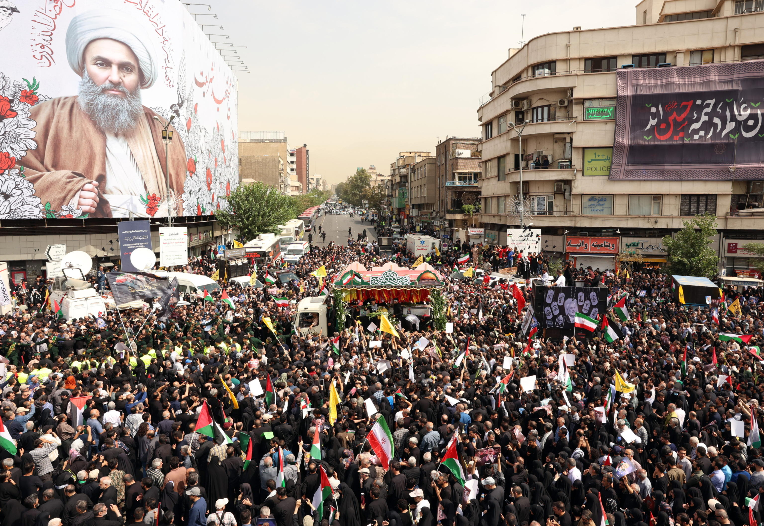 epa11514378 People gather around a truck carrying the coffins of Hamas late political leader Ismail Haniyeh and his bodyguard, during a funeral procession in Tehran, Iran, 01 August 2024. Haniyeh and one of his bodyguards were targeted and killed in Tehran on 31 July 2024, the Iranian Revolutionary Guard Corps (IRGC) confirmed.  EPA/ABEDIN TAHERKENAREH