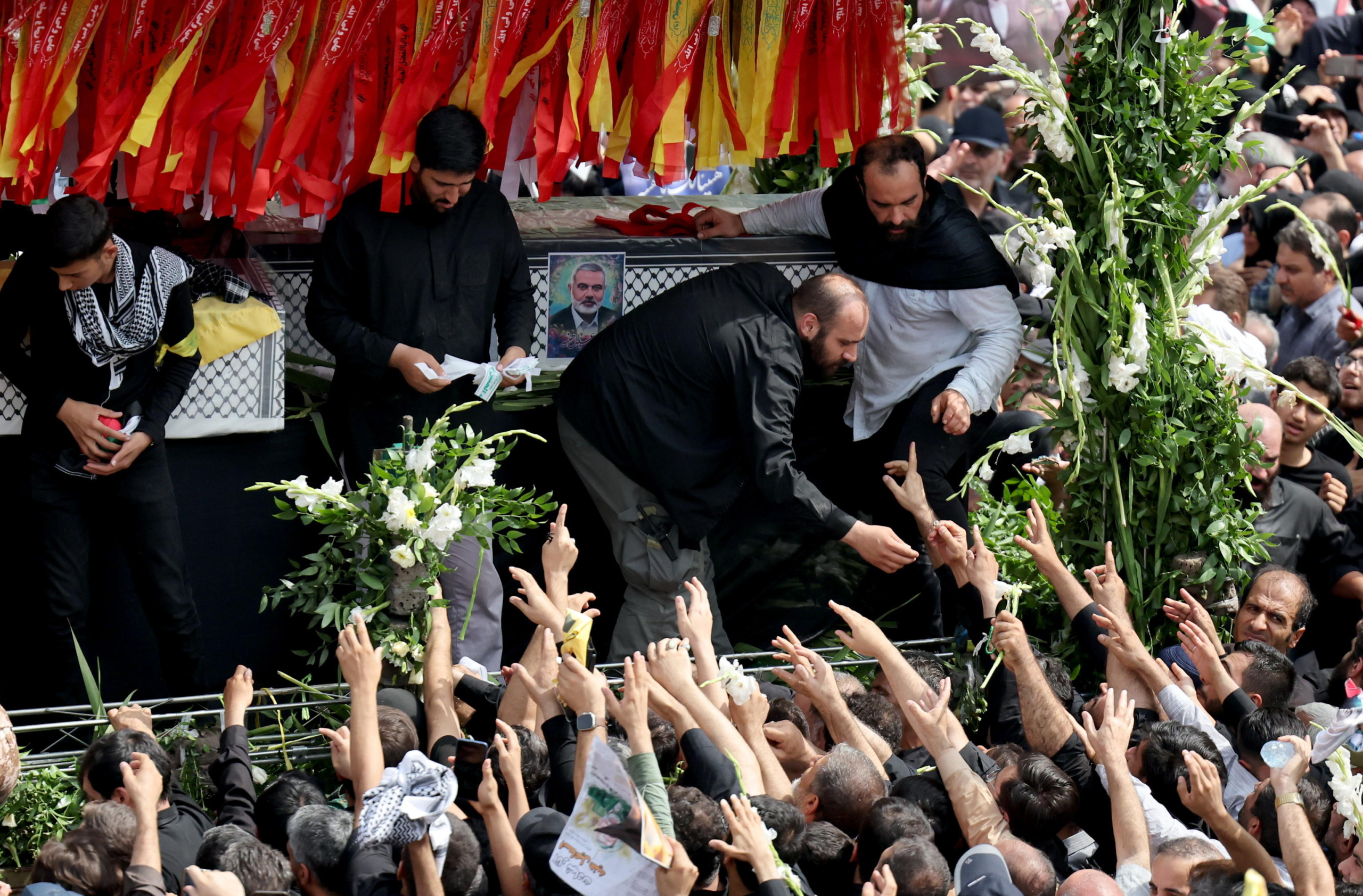 epa11514376 People gather around a truck carrying the coffins of Hamas late political leader Ismail Haniyeh and his bodyguard, during a funeral procession in Tehran, Iran, 01 August 2024. Haniyeh and one of his bodyguards were targeted and killed in Tehran on 31 July 2024, the Iranian Revolutionary Guard Corps (IRGC) confirmed.  EPA/ABEDIN TAHERKENAREH