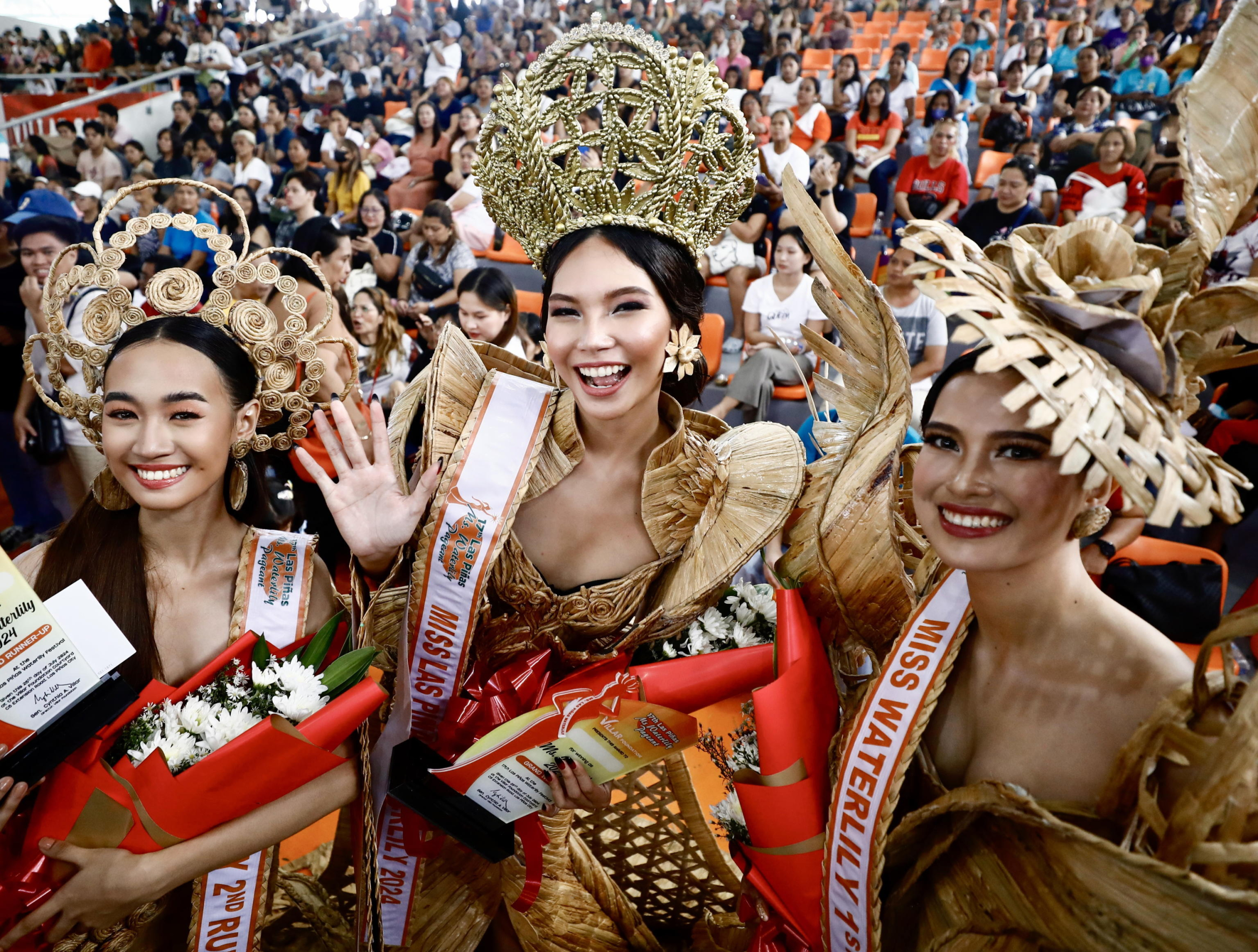 epa11529295 Miss Water Lily 2024 Lois Vivien Garce (C), First runner-up Irish Silades (R) and Second runner-up Micha Selena Rayo (L), wearing gowns made from dried water hyacinth stalks, pose during the Water Lily Festival coronation event in Las Pinas city, Metro Manila, Philippines, 06 August 2024. The annual Water Lily Festival in Las Pinas city was declared by the Villar Foundation to highlight the transformation of water lilies from aquatic nuisances to valuable resources. Through the 'Water Lily Weaving Project', the foundation turns these plants into handicrafts, creating livelihoods and aiding community rehabilitation. During the festival, villagers parade in traditional costumes made from dried water lilies, showcasing the project's success and promoting the benefits of water lily-based livelihoods for local residents.  EPA/FRANCIS R. MALASIG