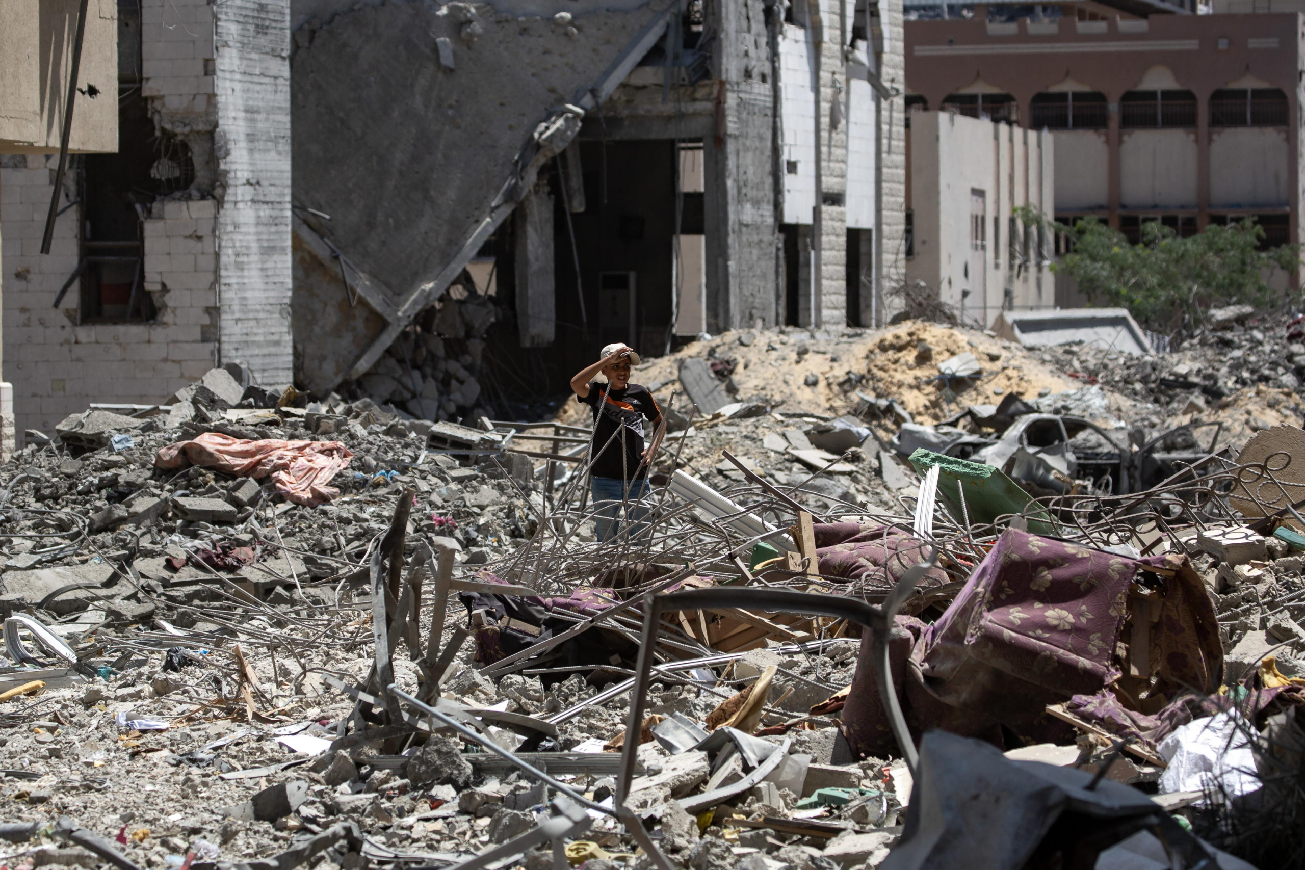 epa11562779 A Palestinian boy inspects the damage after the withdrawal of Israeli forces from Hamad City in Khan Yunis, southern Gaza Strip, 24 August 2024. More than 40,000 Palestinians and over 1,400 Israelis have been killed, according to the Palestinian Health Ministry and the Israel Defense Forces (IDF), since Hamas militants launched an attack against Israel from the Gaza Strip on 07 October 2023, and the Israeli operations in Gaza and the West Bank which followed it.  EPA/HAITHAM IMAD