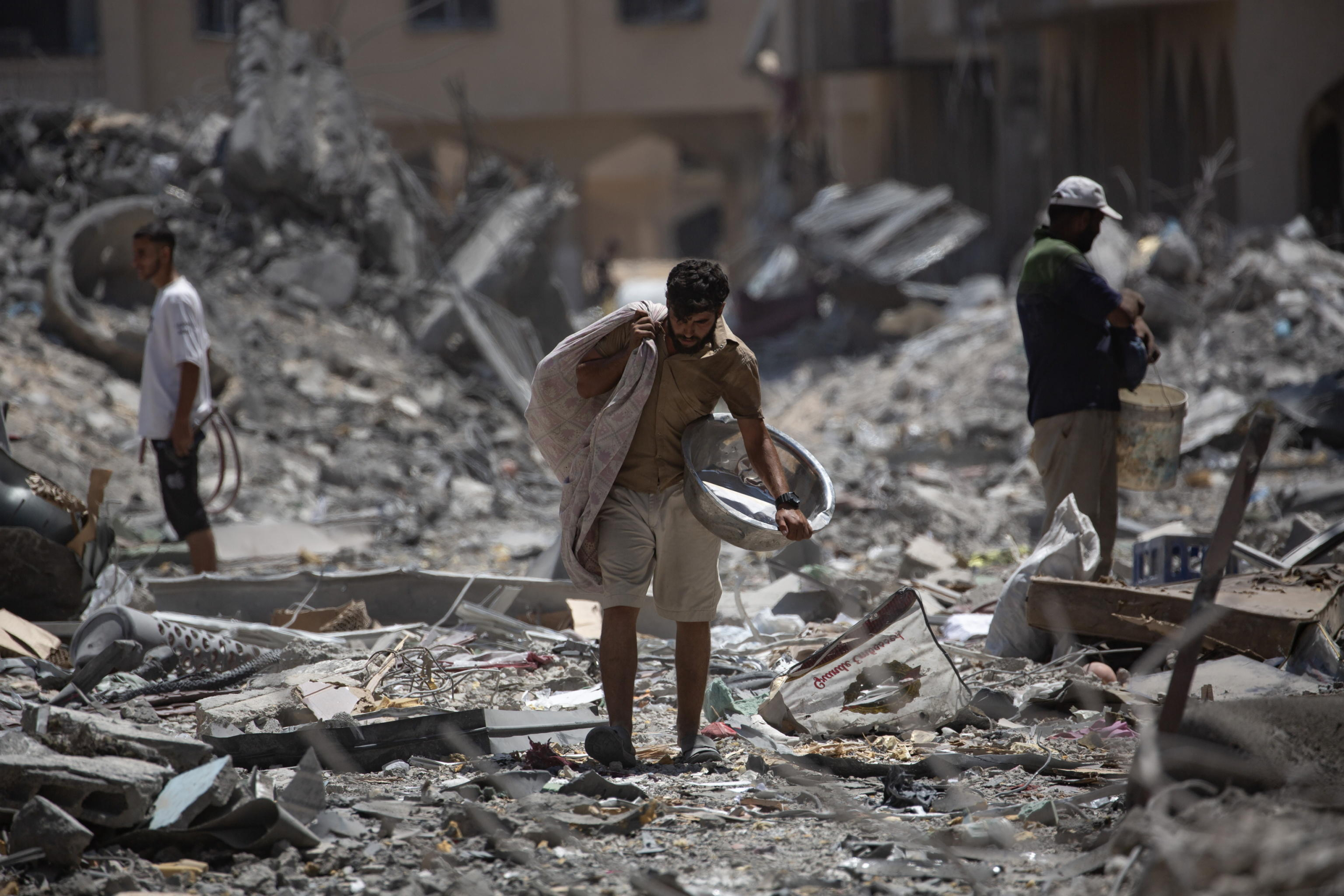 epa11562799 Palestinians inspect the damage after the withdrawal of Israeli forces from Hamad City in Khan Yunis, southern Gaza Strip, 24 August 2024. More than 40,000 Palestinians and over 1,400 Israelis have been killed, according to the Palestinian Health Ministry and the Israel Defense Forces (IDF), since Hamas militants launched an attack against Israel from the Gaza Strip on 07 October 2023, and the Israeli operations in Gaza and the West Bank which followed it.  EPA/HAITHAM IMAD