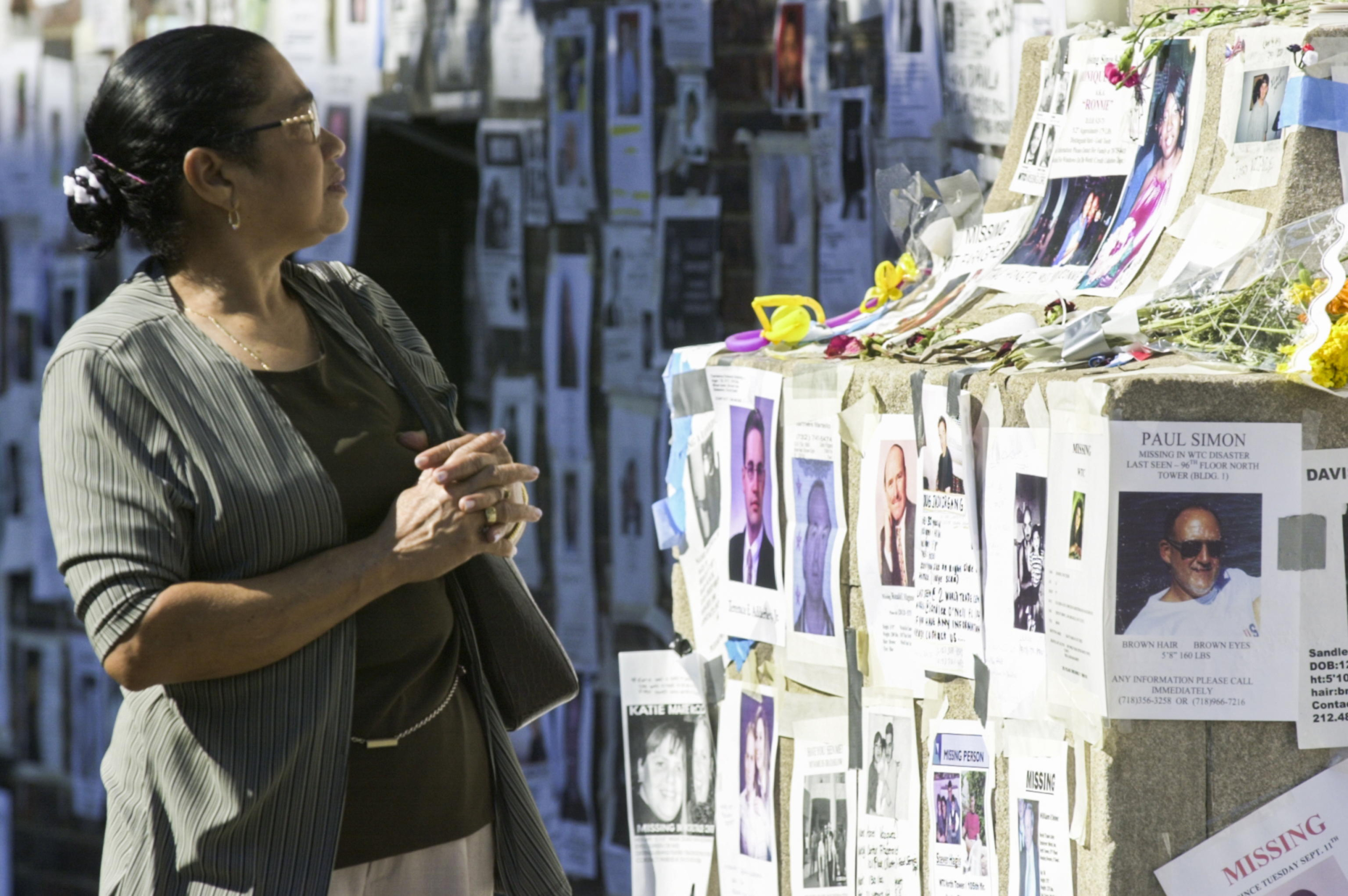 Una donna guarda le foto dei dispersi dopo l'attentato dell'11 settembre 2011 al World Trade Center di New York. Foto Ansa,  EPA/TANNEN MAURY