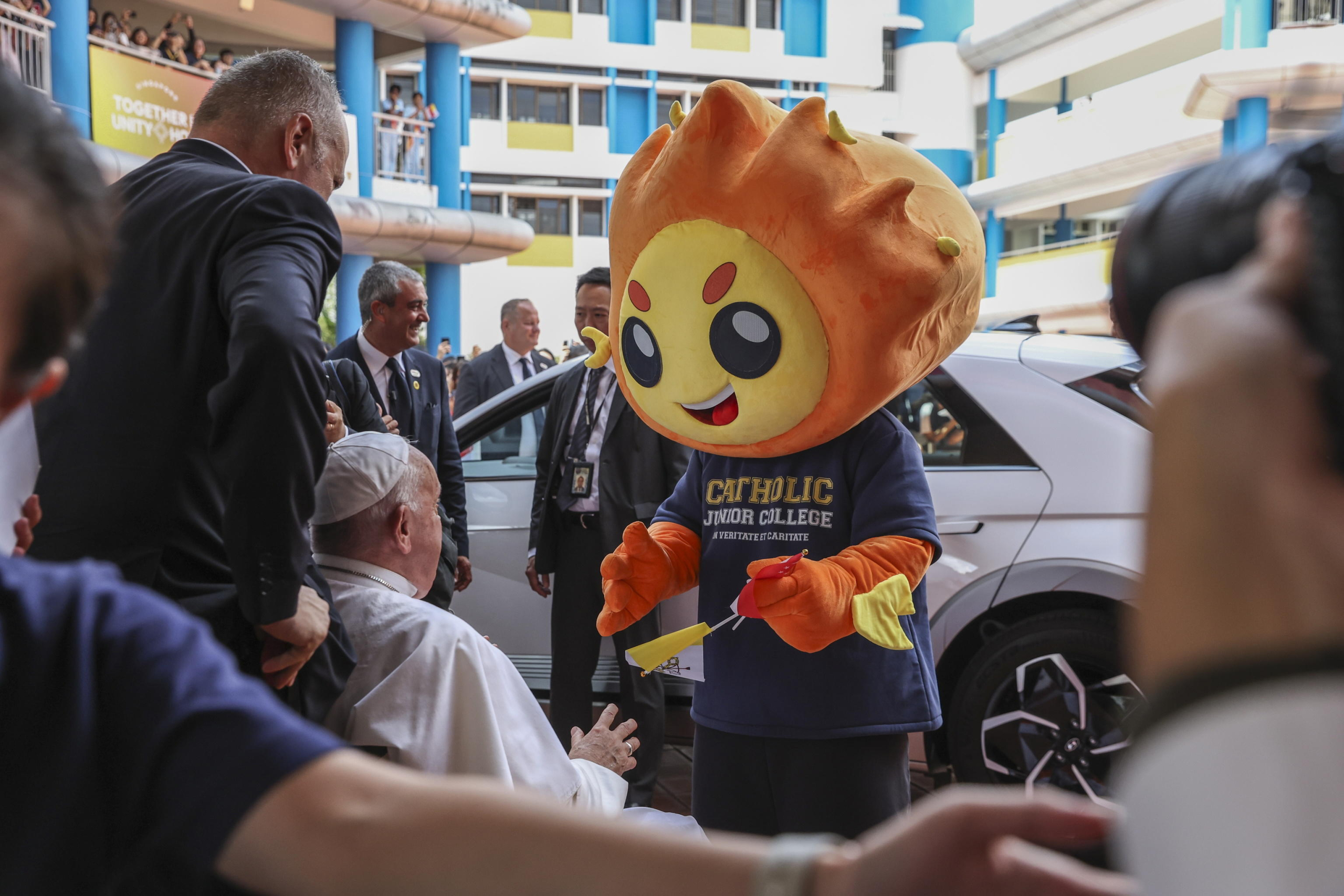 epa11601335 Pope Francis (C-L) greets the mascot of Singapore Catholic Junior College after attending an interreligious meeting with young people at the Catholic Junior College in Singapore, 13 September 2024. Pope Francis is visiting Singapore from 11 to 13 September, marking the final stop of his apostolic journey through the Asia-Pacific region, which also included Indonesia, Papua New Guinea, and East Timor.  EPA/HOW HWEE YOUNG