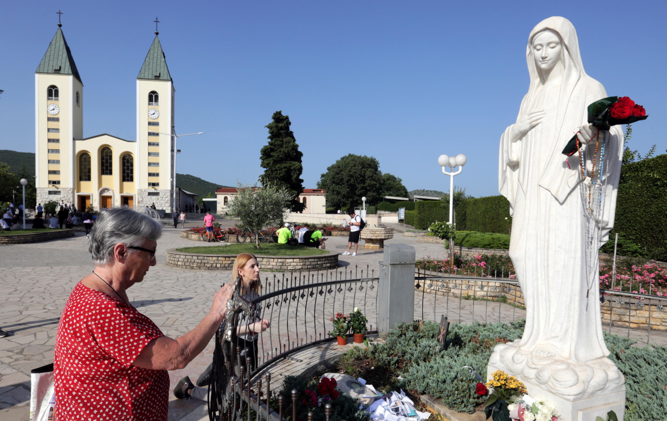 epa10710815 Pilgrims pray in front of the statue of Our Lady of Medjugorje, in the village of Medjugorje, Bosnia and Herzegovina, 25 June 2023. Pilgrims gathered in Medjugorje to mark the 42nd anniversary of the alleged appearance of the Virgin Mary to local shepherds in the hills surrounding the village on 24 June 1981. More than 30 million people are believed to have visited the world-famous village since the Virgin's first appearance, which the Catholic Church has not yet recognized.  EPA/FEHIM DEMIR