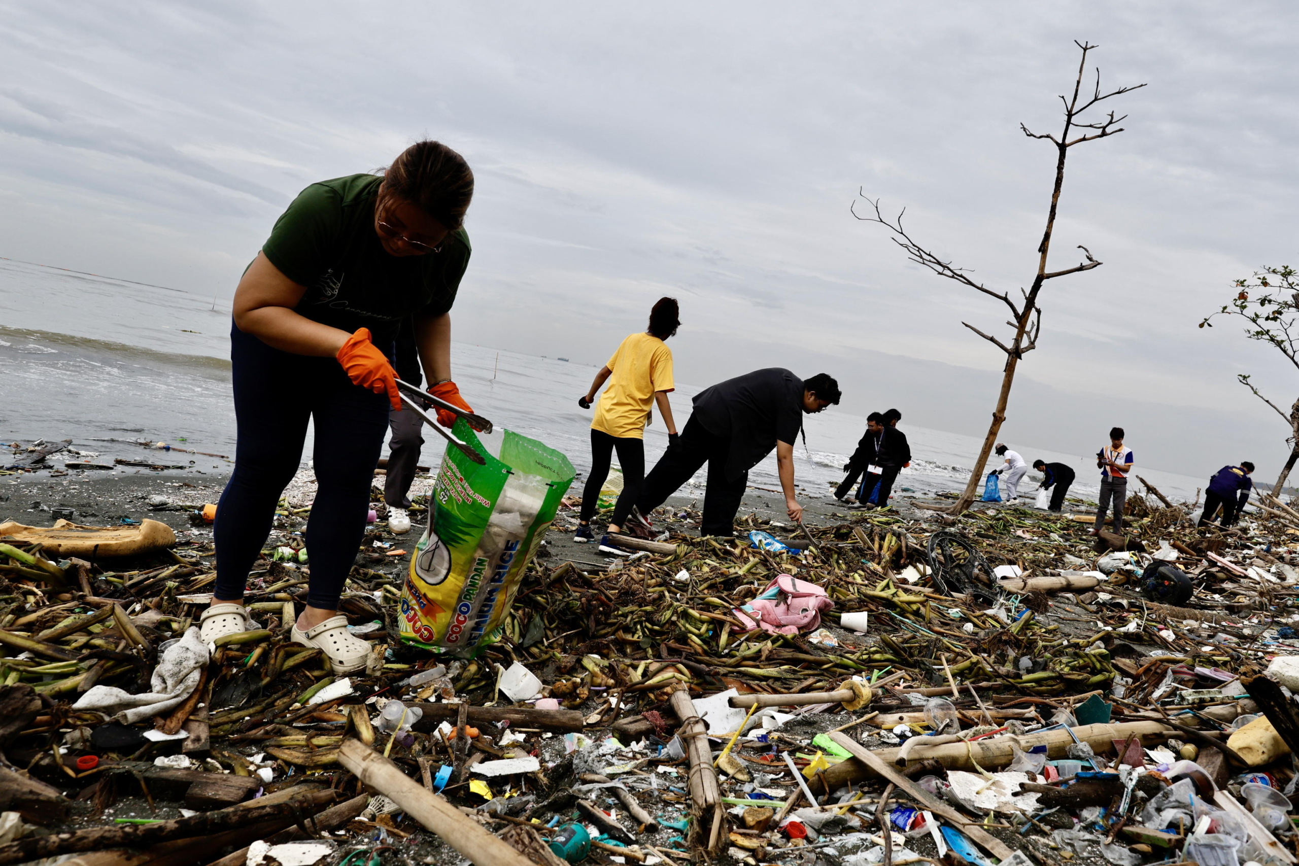 epa11615050 Environmental advocate volunteers collect trash on the eve of International Coastal Cleanup Day in Navotas city, Metro Manila, Philippines, 20 September 2024. International Coastal Cleanup Day is the world's largest volunteer effort for ocean's health that held annually on every third Saturday of September, with this years theme Arctic Cities and Marine Litter.  EPA/FRANCIS R. MALASIG