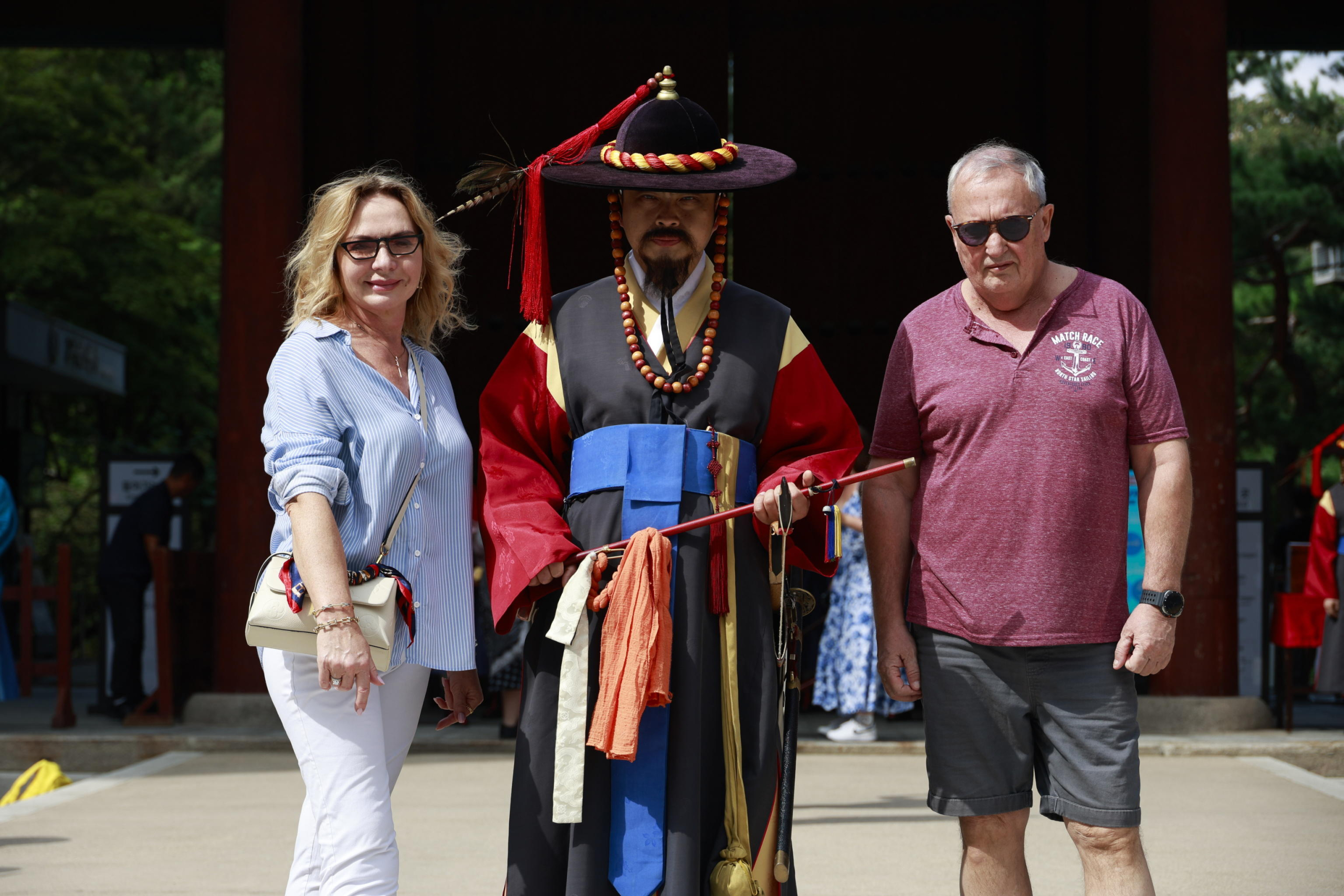 epa11627680 Tourists pose with an employee (C) of Korea Heritage Service, wearing Royal Guard uniform, after performance of the changing of the guard ceremony at Deoksugung Palace on the World Tourism Day in Seoul, South Korea, 27 September 2024. World Tourism Day has been observed annually since 1980 on 27 September.  EPA/JEON HEON-KYUN