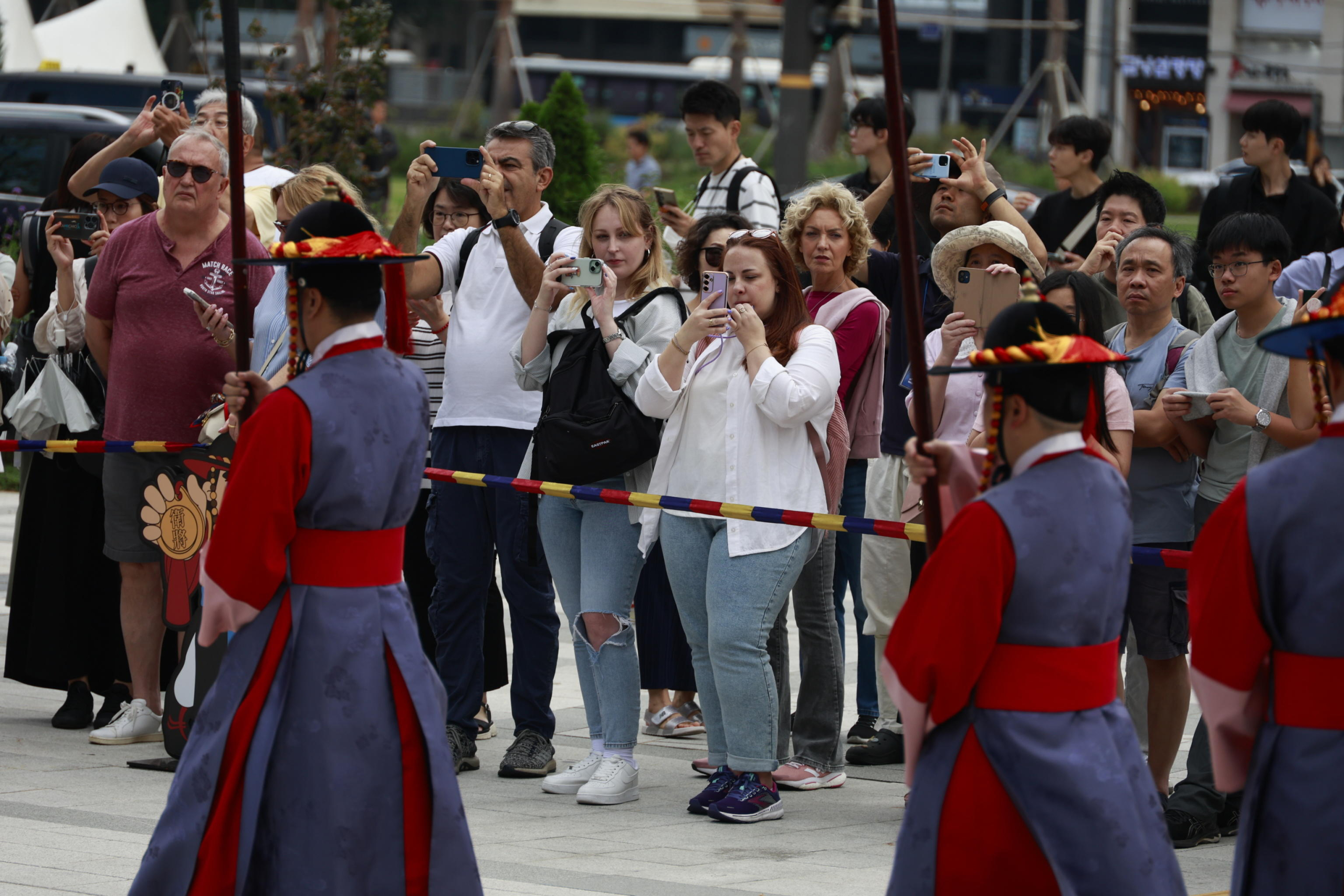 epa11627678 Tourists look at a performance of the changing of the guard ceremony at Deoksugung Palace on the World Tourism Day in Seoul, South Korea, 27 September 2024. World Tourism Day has been observed annually since 1980 on 27 September.  EPA/JEON HEON-KYUN