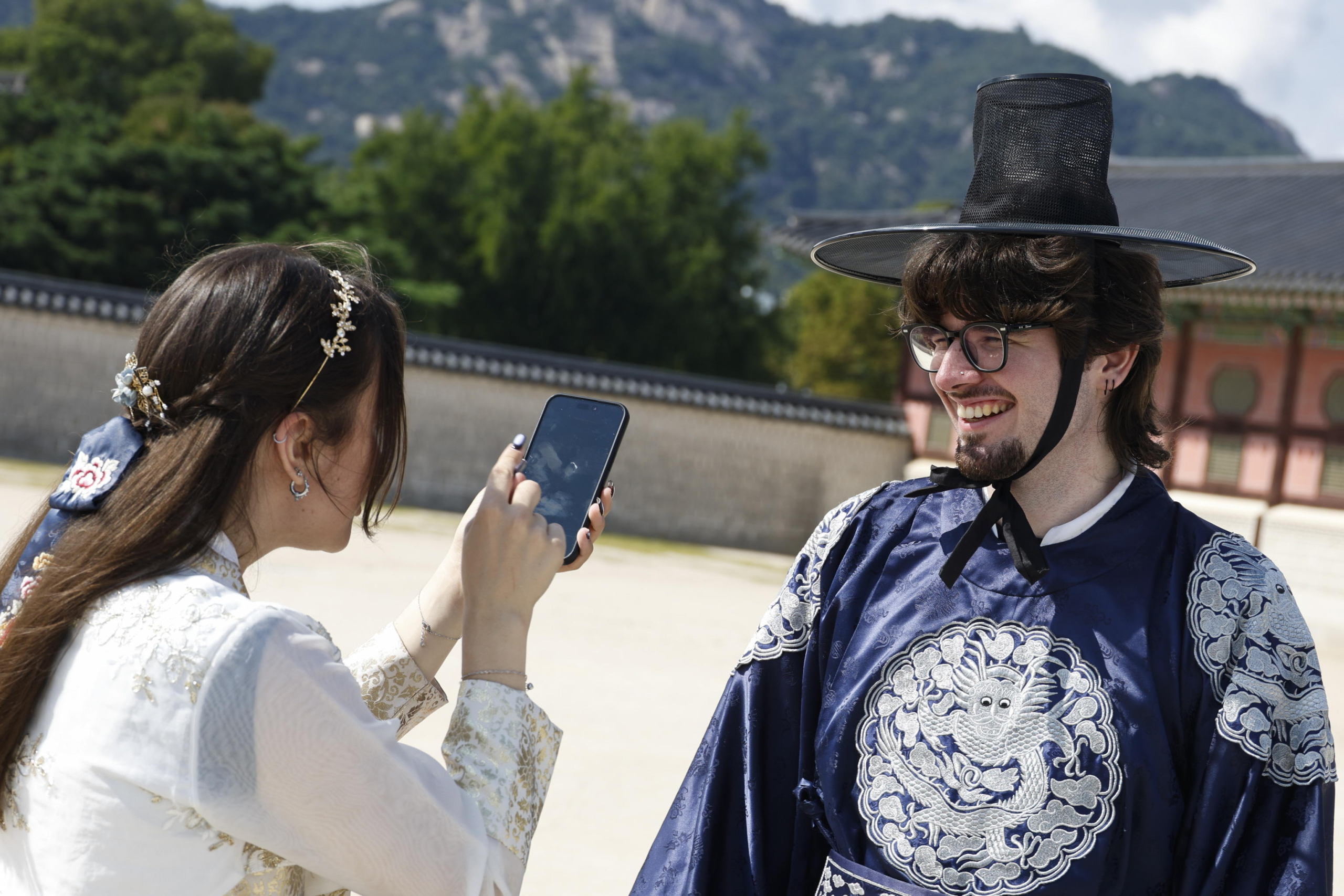 epa11627686 Tourists wearing traditional Korean clothes 'Hanbok' take a pictures as they visit the Gyeongbokgung Palace on the World Tourism Day in Seoul, South Korea, 27 September 2024.  World Tourism Day has been observed annually since 1980 on 27 September.  EPA/JEON HEON-KYUN