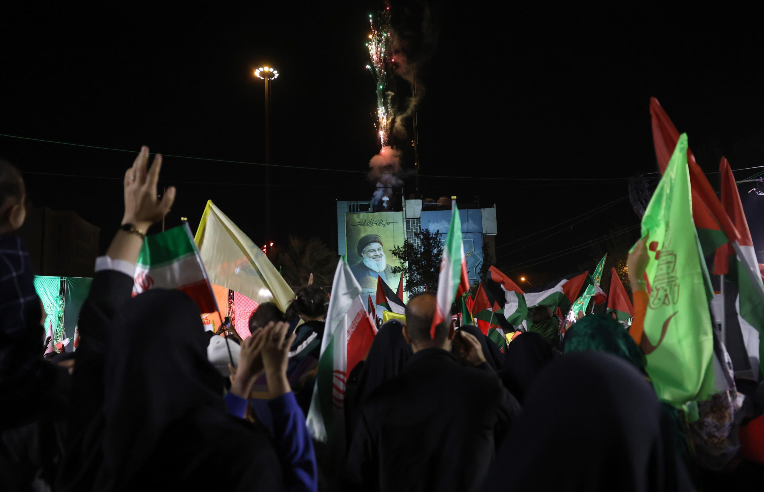 epa11636866 Around a huge billboard of late Hezbollah leader Hassan Nasrallah Iranians celebrate after Iran launched a missile attack on Israel, in Palestine Square, in Tehran, Iran, 01 October 2024. Iran has launched dozens of missiles directed at Israel on 01 October 2024, state media reported quoting the Islamic Revolutionary Guard Corps (IRGC). The attack was a 'retaliation for different assassinations' carried out by Israel and 'the crimes in Palestine and Lebanon', IRGC said.  EPA/ABEDIN TAHERKENAREH