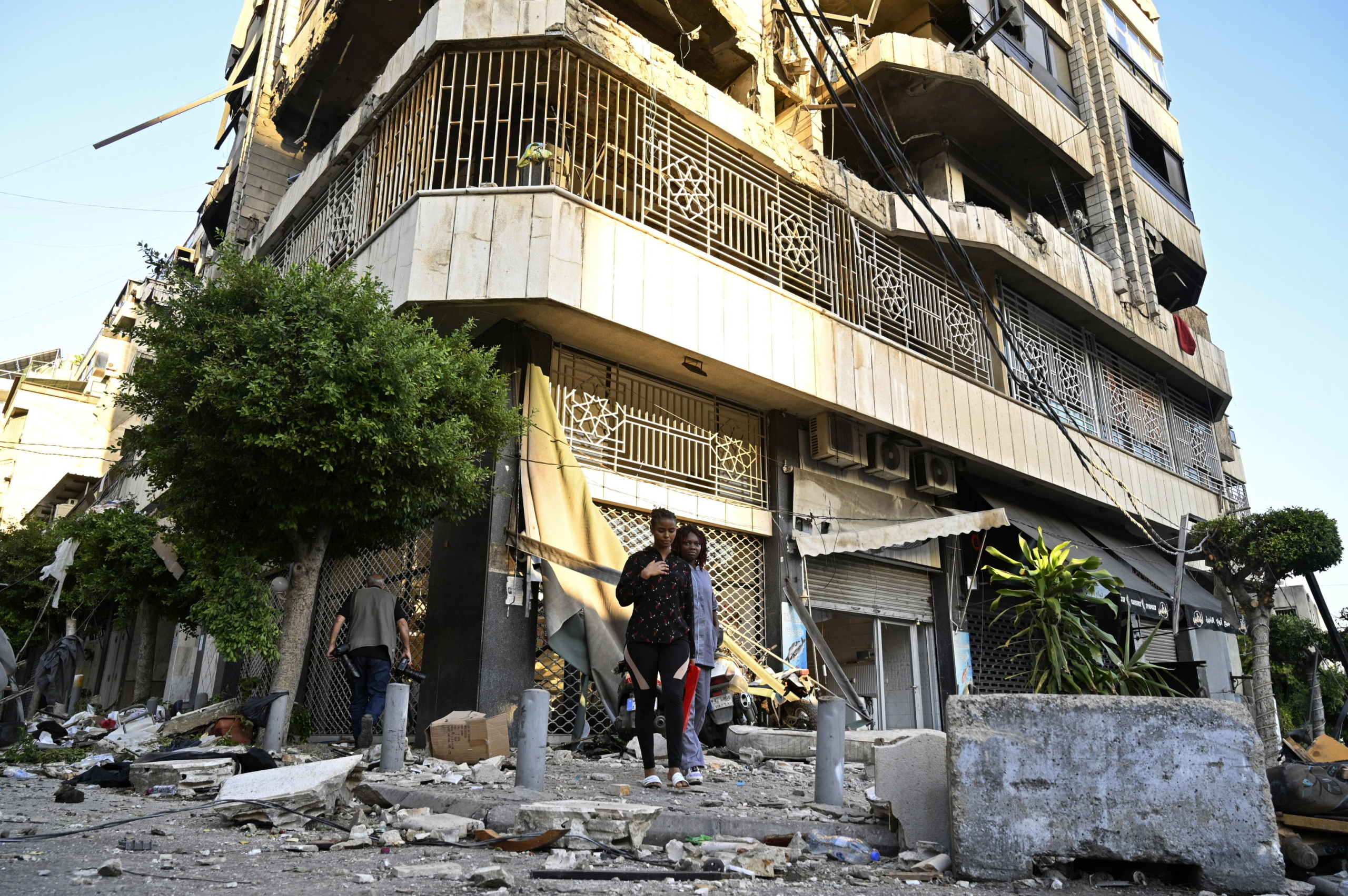 epa11639141 People stand near a damaged building following an Israeli airstrike in Beirut's Bachoura neighborhood, Lebanon, 03 October 2024. Lebanese officials reported that an Israeli airstrike on a building in central Beirut resulted in at least five deaths and eight injuries.  EPA/WAEL HAMZEH