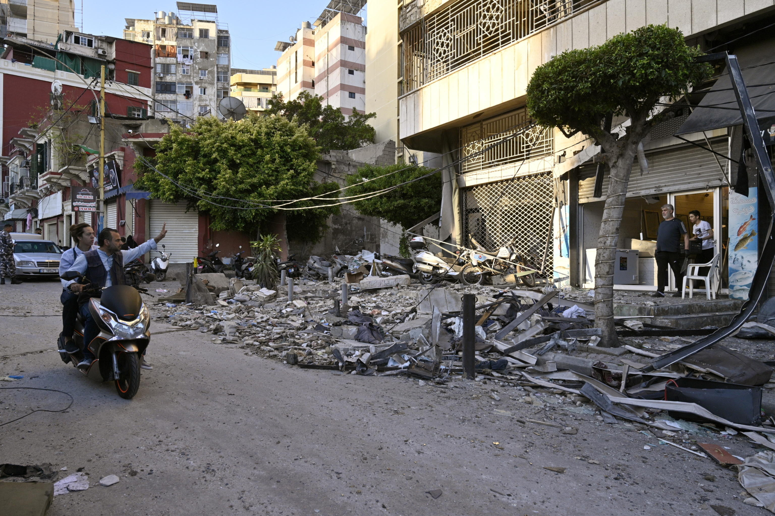 epa11639145 People ride a motobike near debris following an Israeli airstrike in Beirut's Bachoura neighborhood, Lebanon, 03 October 2024. Lebanese officials reported that an Israeli airstrike on a building in central Beirut resulted in at least five deaths and eight injuries.  EPA/WAEL HAMZEH