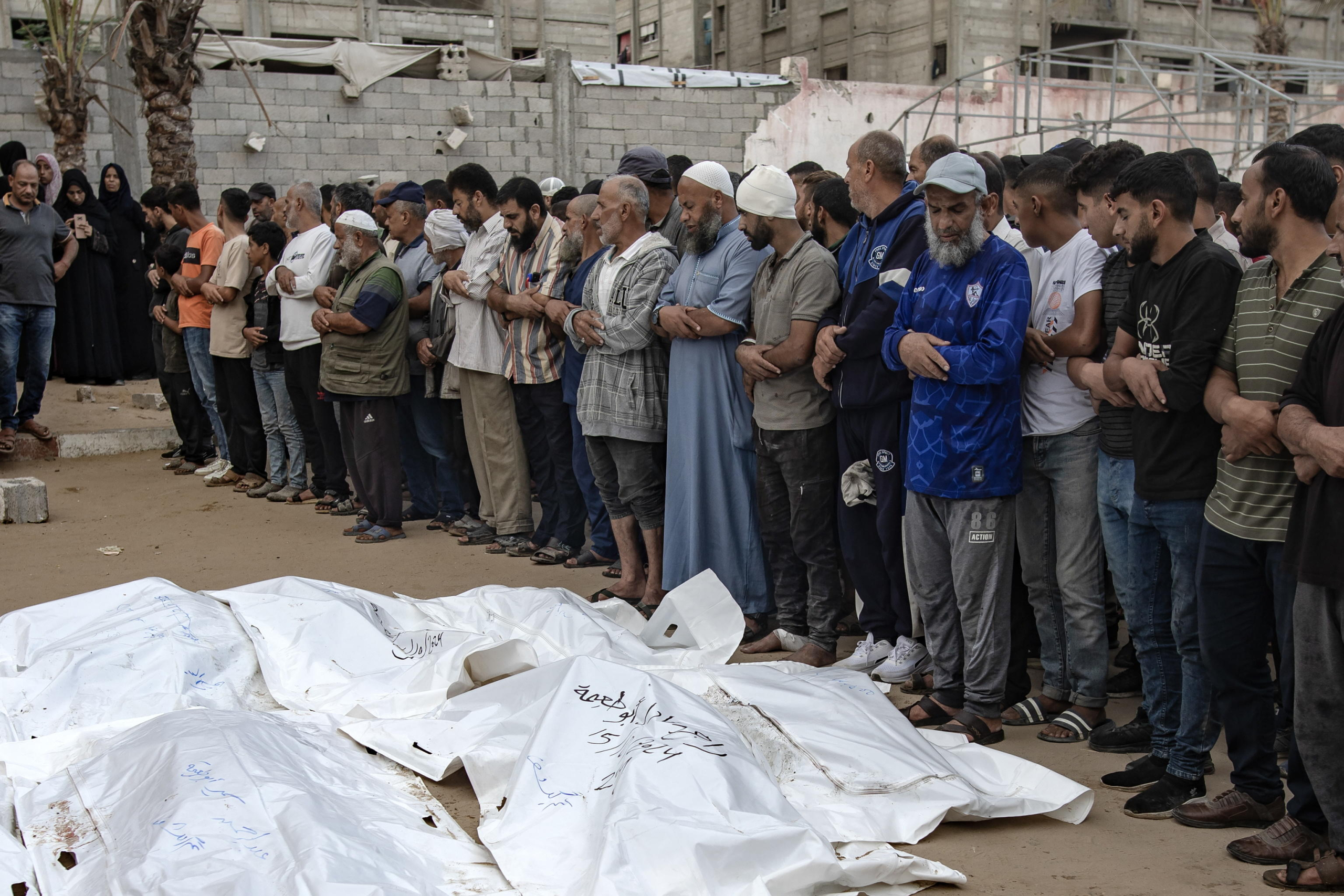 epa11659963 Palestinians, including victims' relatives, pray next to the bodies of members of the Abu Taima family, killed in an Israeli air strike, at the Khan Younis refugee camp, southern Gaza Strip, 15 October 2024. According to Nasser Hospital, at least 10 members of an extended family were killed in an Israeli airstrike on their home in Bani Suhaila, east of Khan Younis early on 15 October. More than 42,200 Palestinians and over 1,400 Israelis have been killed, according to the Palestinian Health Ministry and the Israeli Army, Tsahal, since Hamas militants launched an attack against Israel from the Gaza Strip on 07 October 2023, and the Israeli operations in Gaza and the West Bank which followed it.  EPA/HAITHAM IMAD