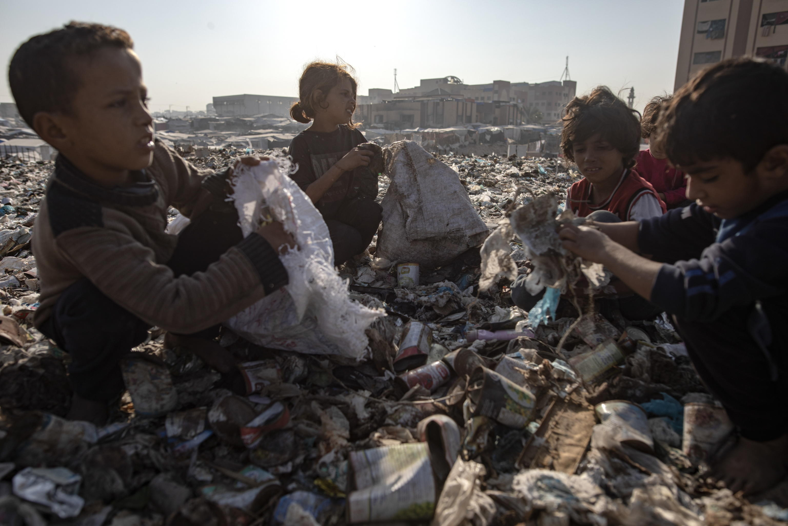 epa11700537 Palestinian children sort through garbage as they collect plastic from a landfill, amid a shortage of cooking gas and fuel, at the Khan Younis refugee camp, in the southern Gaza Strip, 04 November 2024. A United Nations Office for the Coordination of Humanitarian Affairs (OCHA) assessment carried out across some IDP camps in Gaza in May 2024 pointed to 'makeshift dwellings being made of blankets, nylon, and foraged materials. With no electricity, and cooking gas and wood being too expensive, families were resorting to burning trash and plastic to cook.' According to the UN, at least 1.9 million people across the Gaza Strip are internally displaced. Since October 2023, only about 11 percent of the Gaza Strip has not been placed under Israeli-issued evacuation orders, the UN aid coordination office OCHA said.  EPA/HAITHAM IMAD