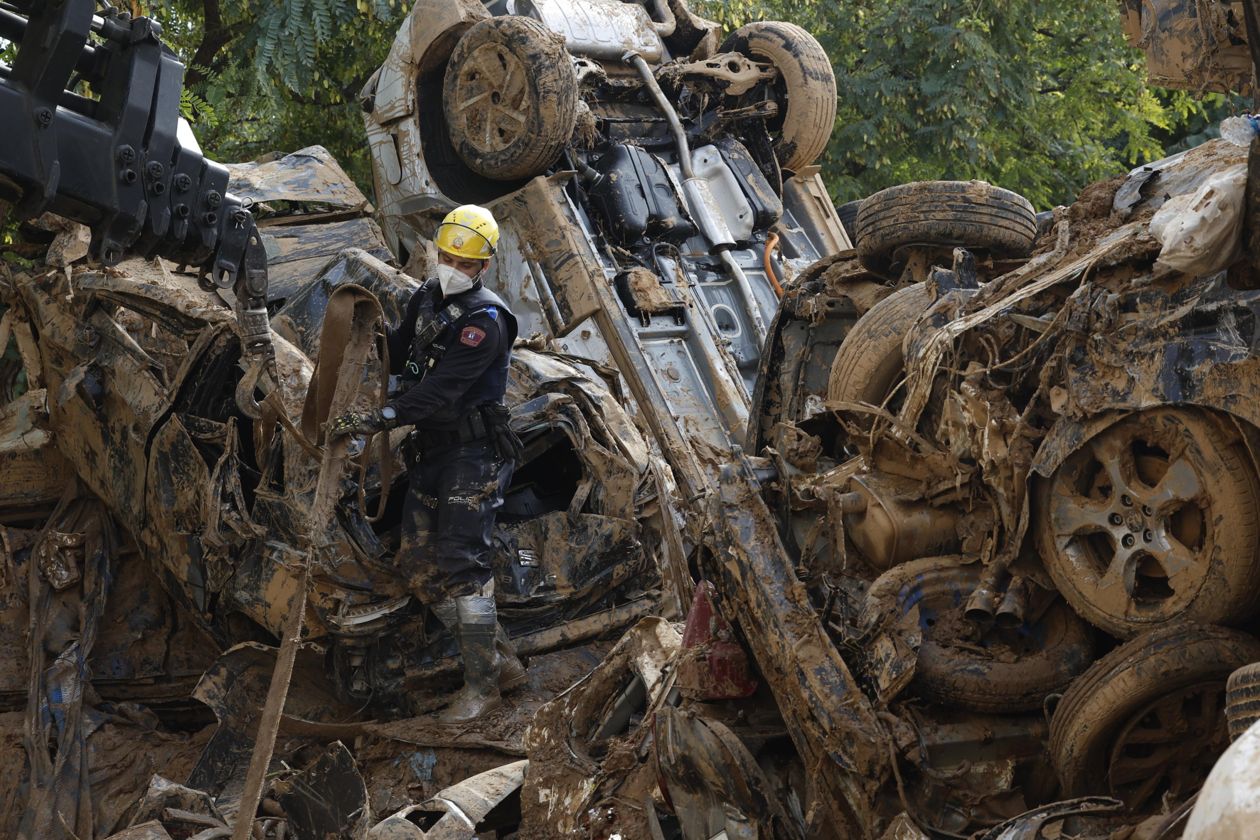 epa11709882 Madrid's local policemen help to remove pile of flood damaged cars in Alfafar, in Valencia Spain, 08 November 2024. The devastating floods in Valencia and neighboring provinces have caused at least 216 fatalities, as efforts continue to search for missing people, provide supplies, and care for the victims after the DANA (high-altitude isolated depression) weather phenomenon hit the east of the country on 29 October.  EPA/CHEMA MOYA