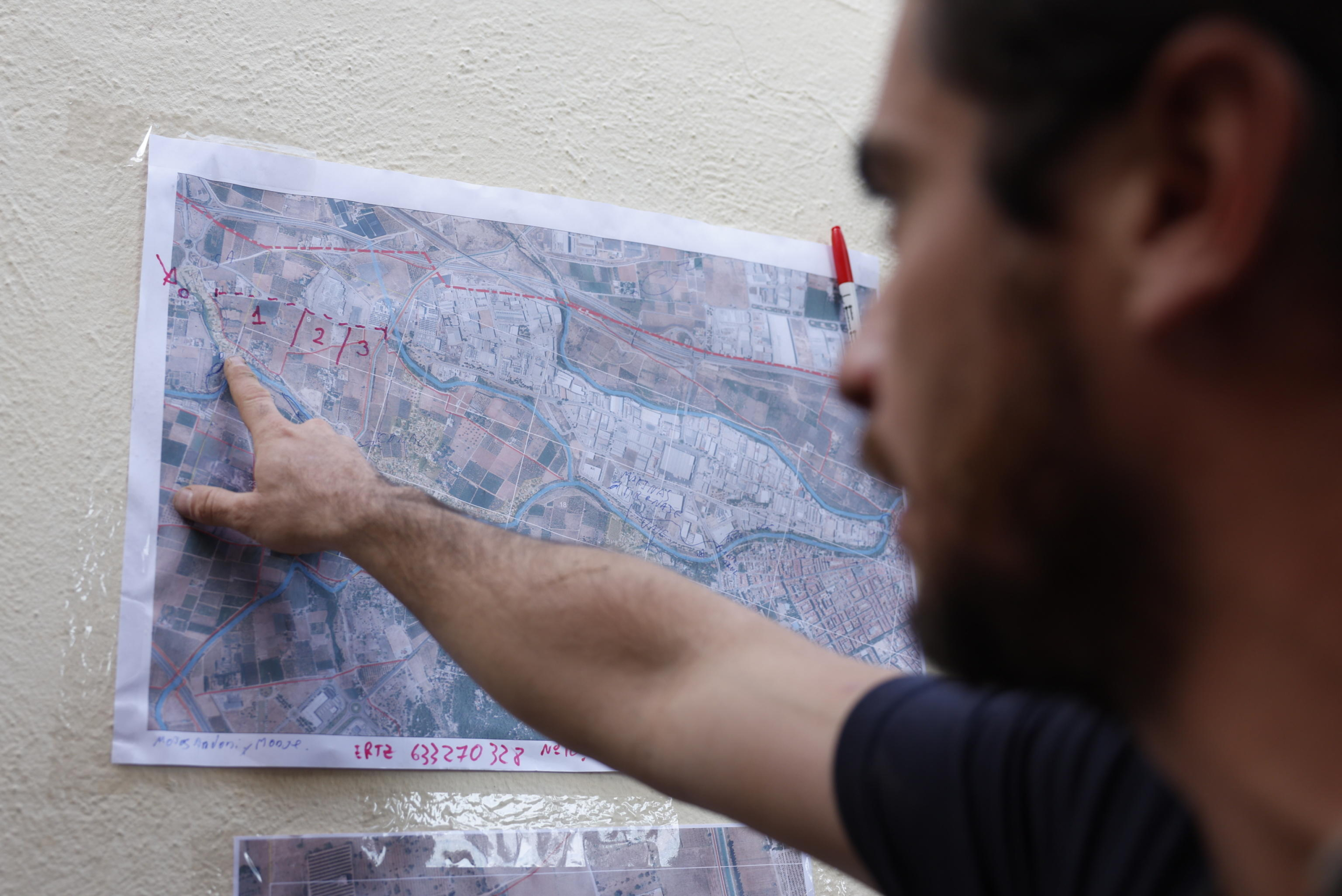 epa11709550 A volunteer indicates an area on a map before conducting searches for dead bodies in the village of Torrent, Valecia Spain, 08 November 2024. The devastating floods in Valencia and neighboring provinces have caused at least 216 fatalities, as efforts continue to search for missing people, provide supplies, and care for the victims after the DANA (high-altitude isolated depression) weather phenomenon hit the east of the country on 29 October.  EPA/JORGE ZAPATA