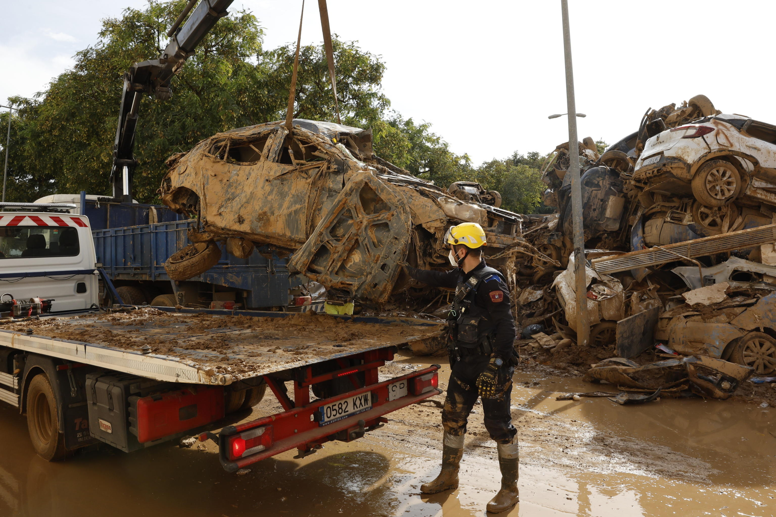 epa11709881 Madrid's local policemen help to remove pile of flood damaged cars in Alfafar, in Valencia Spain, 08 November 2024. The devastating floods in Valencia and neighboring provinces have caused at least 216 fatalities, as efforts continue to search for missing people, provide supplies, and care for the victims after the DANA (high-altitude isolated depression) weather phenomenon hit the east of the country on 29 October.  EPA/CHEMA MOYA