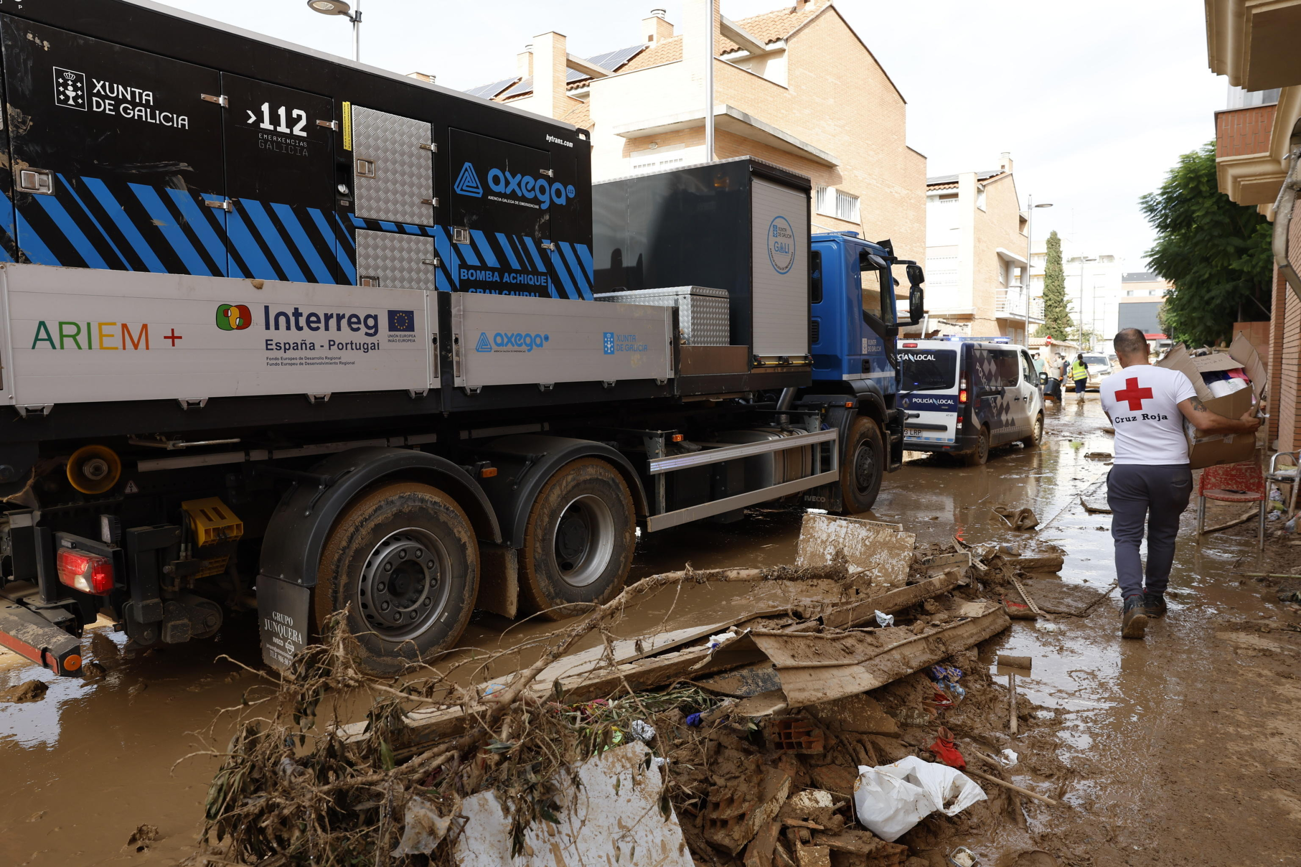 epa11709878 A Red Cross member walks on a mud-covered street, during works for cleaning the streets of Alfafar, in Valencia Spain, 08 November 2024. The devastating floods in Valencia and neighboring provinces have caused at least 216 fatalities, as efforts continue to search for missing people, provide supplies, and care for the victims after the DANA (high-altitude isolated depression) weather phenomenon hit the east of the country on 29 October.  EPA/CHEMA MOYA