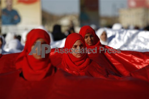 Yemen. Ragazze avvolte in una bandiera rossa celebrano l'anniversario della rivoluzione di Sanaa