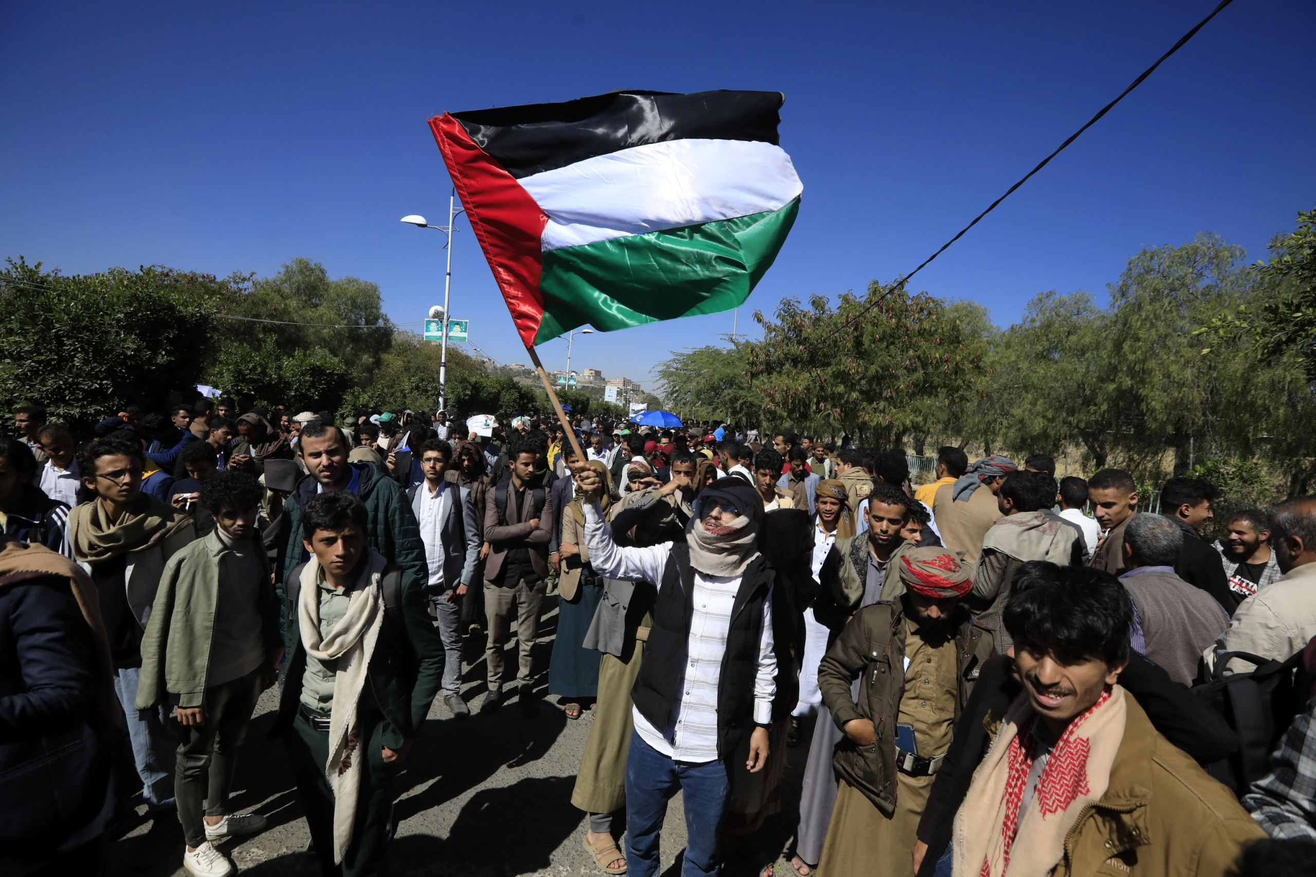 epa11744345 A student waves a Palestinian flag during a rally in solidarity with the Lebanese and Palestinian people, in Sana'a, Yemen, 27 November 2024. University students and academics have rallied in Sana'a to express their solidarity with the Lebanese and Palestinian people and to condemn the Israeli airstrikes in Lebanon and the Gaza Strip.  EPA/YAHYA ARHAB