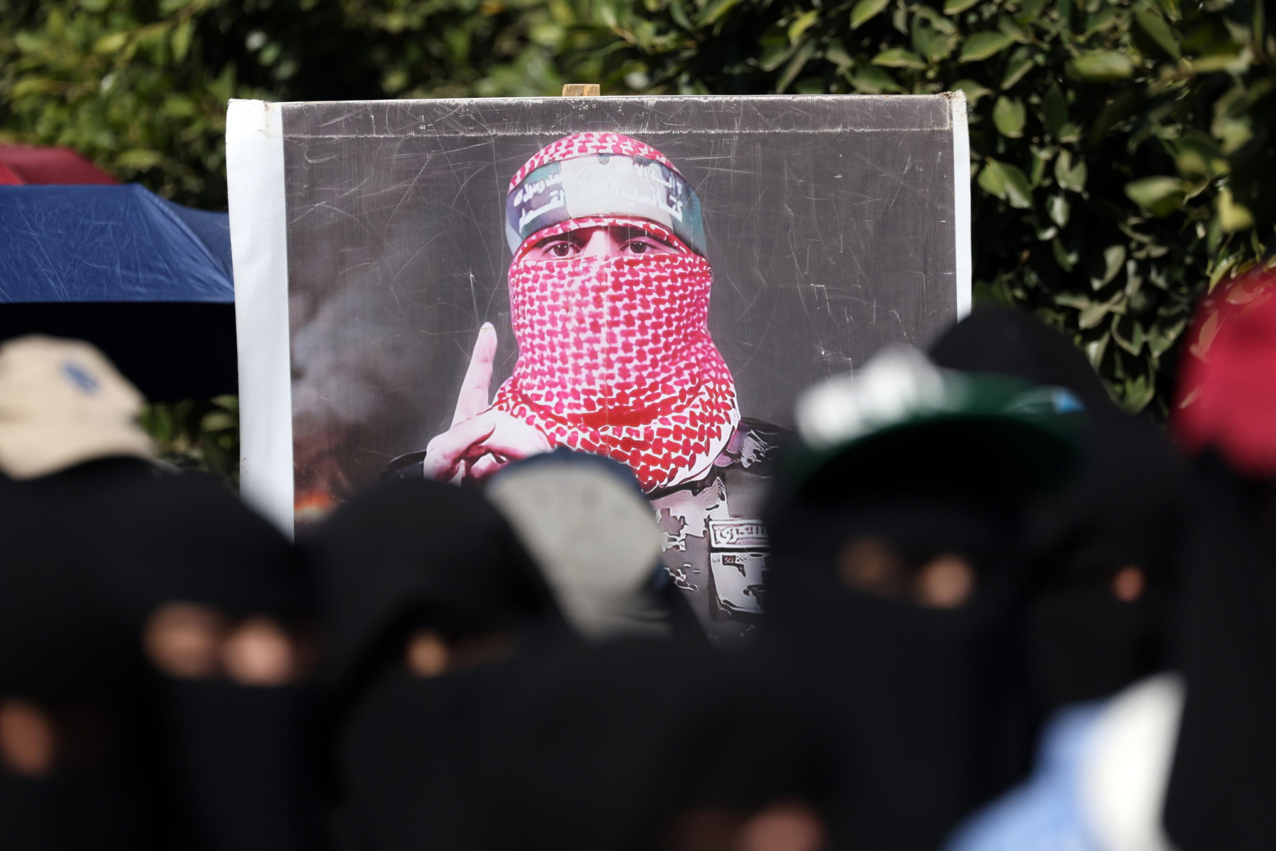 epa11744363 Students hold a placard showing the spokesperson of Hamas' military wing Al-Qassam Brigades, Abu Obaida, during a rally in solidarity with the Lebanese and Palestinian people, in Sana'a, Yemen, 27 November 2024. University students and academics have rallied in Sana'a to express their solidarity with the Lebanese and Palestinian people and to condemn the Israeli airstrikes in Lebanon and the Gaza Strip.  EPA/YAHYA ARHAB