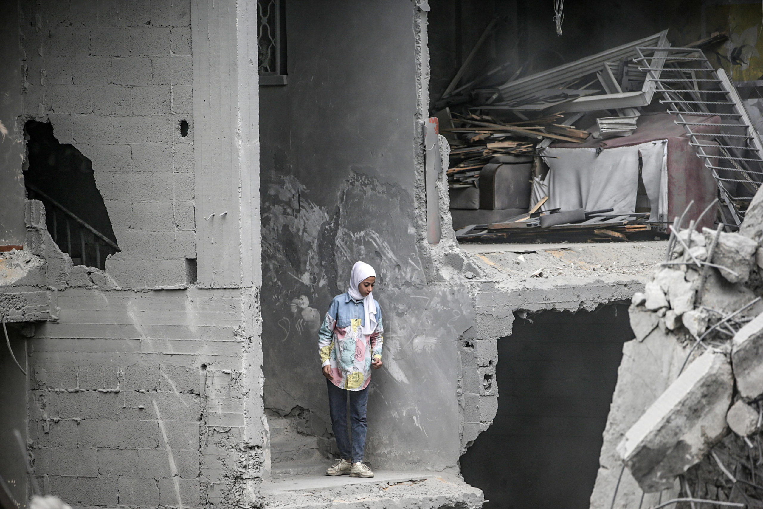 epa11743759 A Palestinian girl inspects a house neighbouring the Al-Qassam Mosque, both destroyed as a result of an overnight Israeli air strike on Al-Nuseirat refugee camp, in central Gaza Strip, 27 November 2024. More than 44,200 Palestinians and over 1,400 Israelis have been killed, according to the Palestinian Health Ministry and the Israeli Army, since Hamas militants launched an attack against Israel from the Gaza Strip on 07 October 2023, and the Israeli operations in Gaza and the West Bank which followed it.  EPA/MOHAMMED SABER