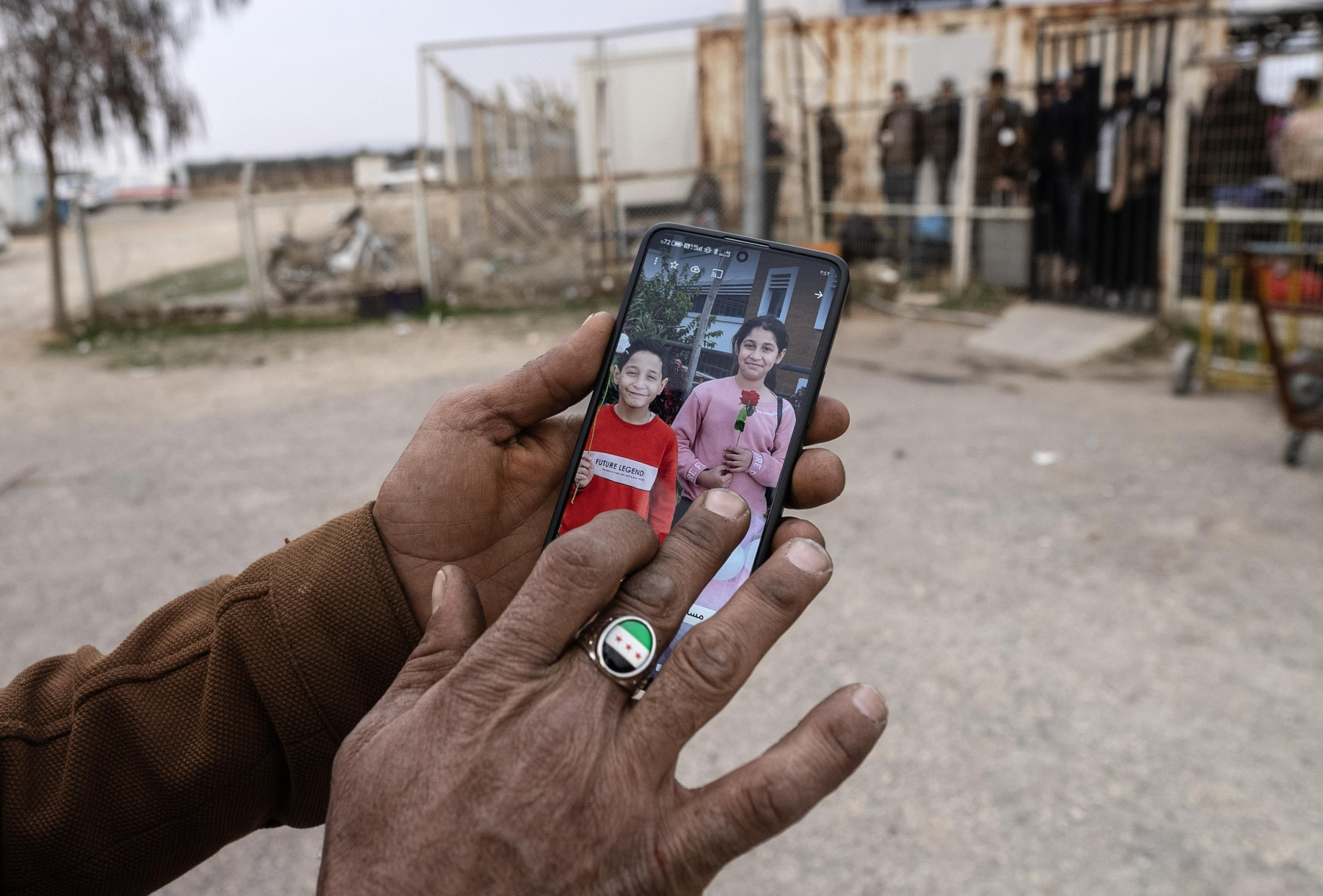 epa11772615 Syrian Adik Berfo, who works as a luggage carrier and translator for those who cross the border into Syria, shows his children's picture at the Oncupinar border gate, near the town of Kilis, southern Turkey, 12 December 2024. The Political Affairs Department of the Syrian Salvation government called for all refugees outside Syria to return following the ousting of Syrian President Bashar al-Assad on 08 December, as the UN Refugee Agency (UNHCR) estimates that since 2011, more than 14 million Syrians were forced to flee their homes in search of safety.  EPA/KAZIM KIZIL