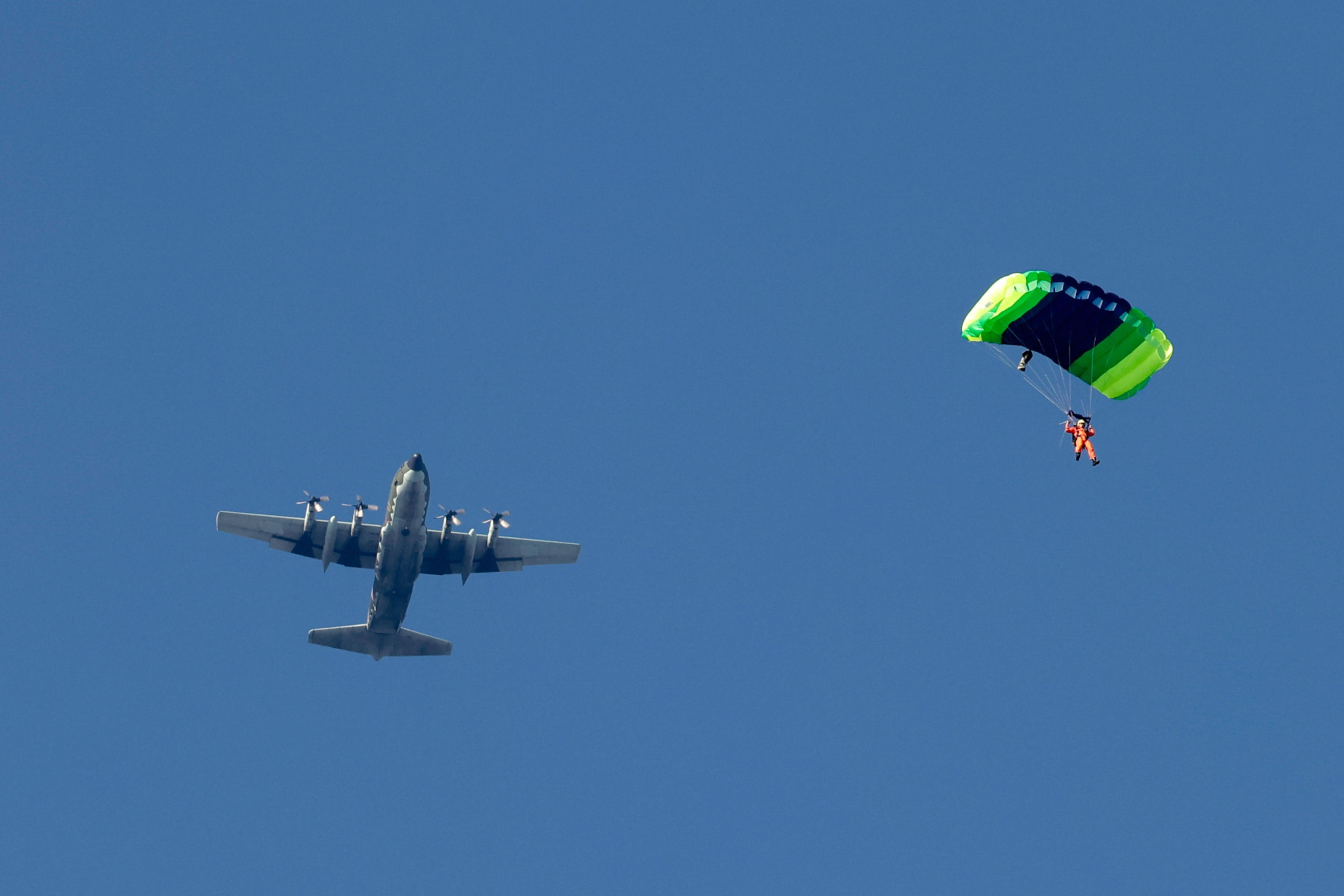 epa11786577 A Taiwanese paratrooper jumps from a C-130 plane during a live training session in Pingtung city, Taiwan, 20 December 2024. According to a 18 December report published by the United States Department of Defense (DoD), in 2023, China continued to increase diplomatic, political, and military pressure against Taiwan.  EPA/RITCHIE B. TONGO