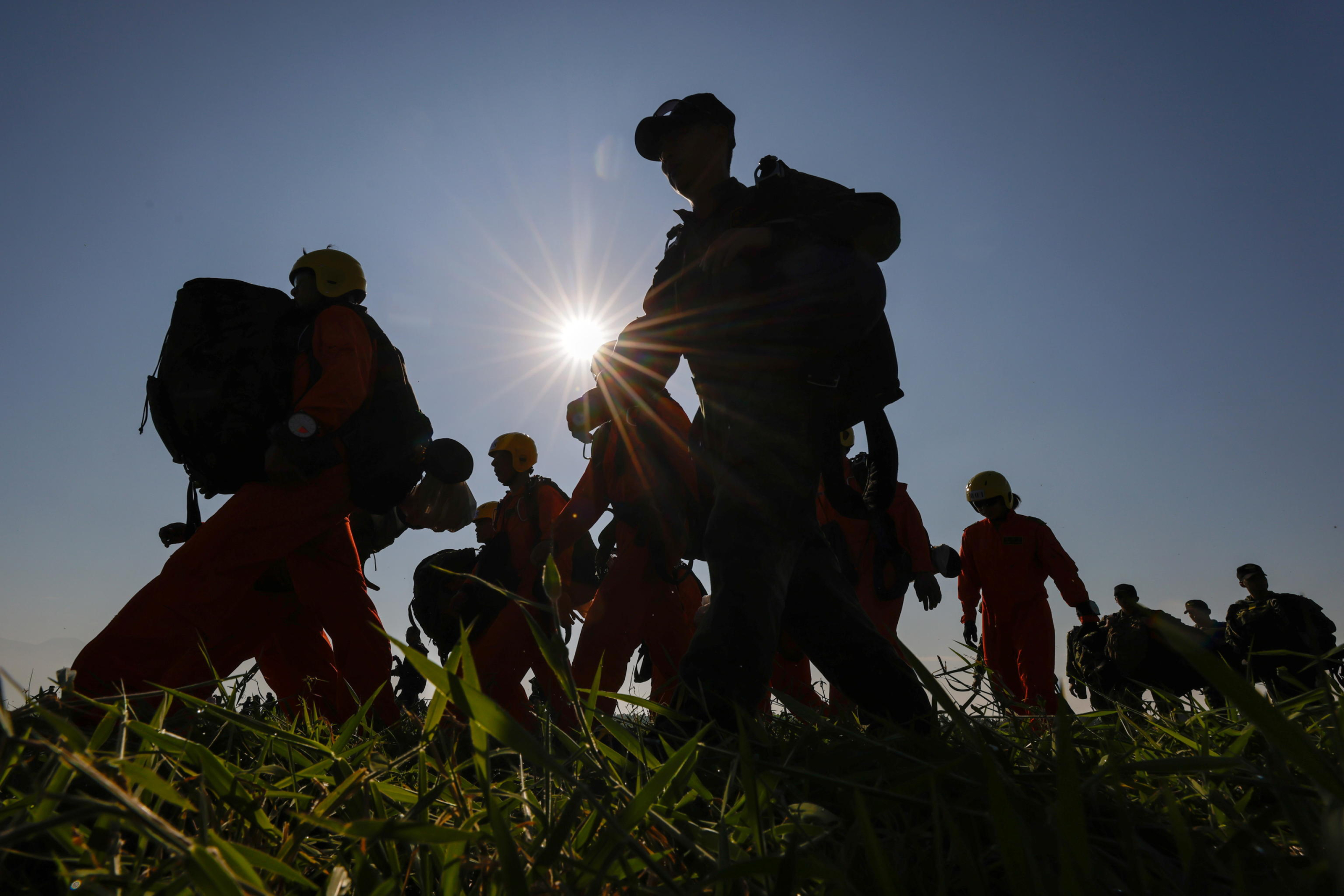 epa11786587 Taiwanese paratroopers carry their parachutes after jumping from a C-130 plane during a live training session in Pingtung city, Taiwan, 20 December 2024. According to a 18 December report published by the United States Department of Defense (DoD), China continued to increase diplomatic, political, and military pressure against Taiwan in 2023.  EPA/RITCHIE B. TONGO