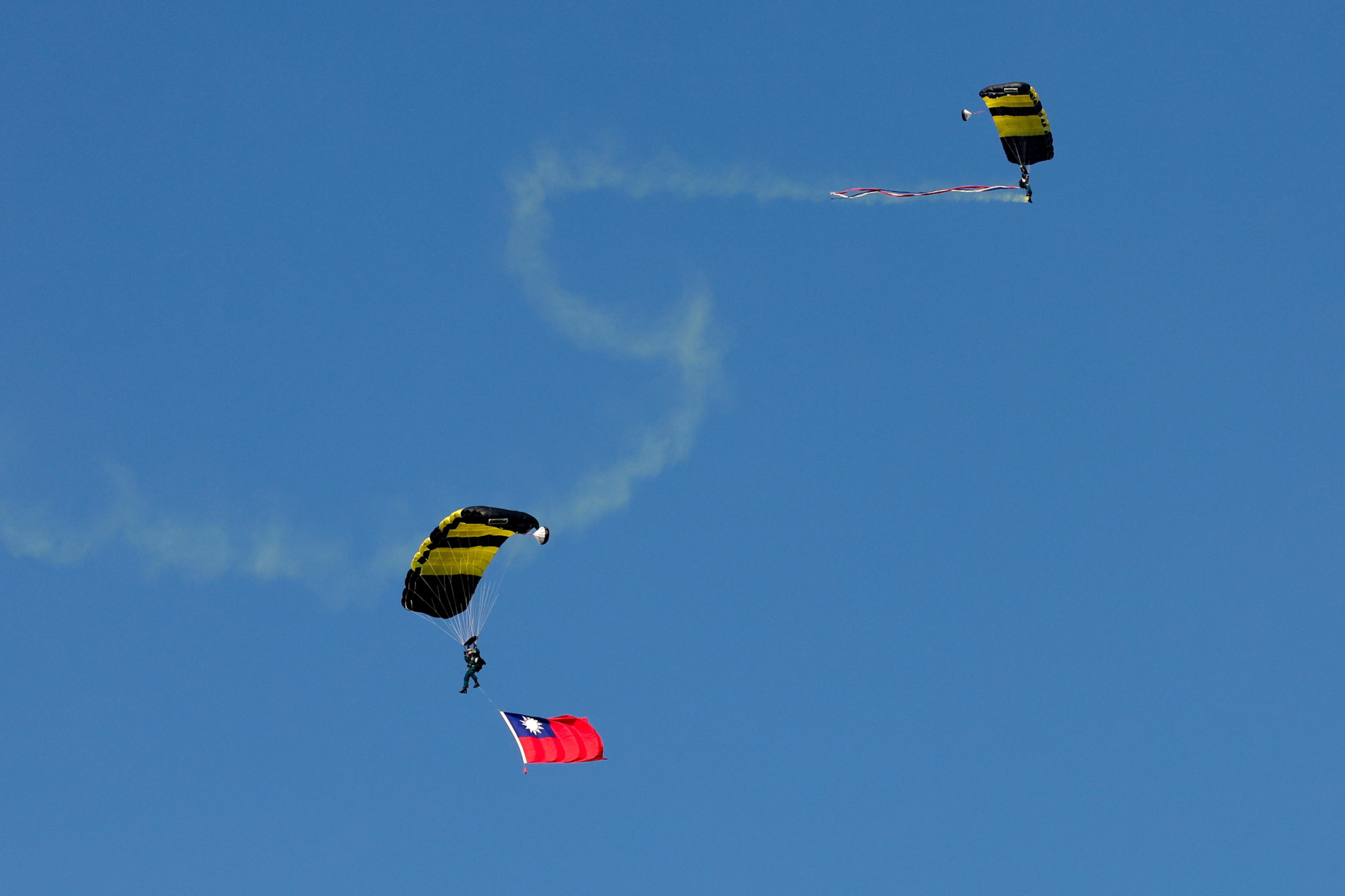 epa11786588 A Taiwanese paratrooper hoists the national flag during a live training session in Pingtung city, Taiwan, 20 December 2024. According to an 18 December report published by the United States Department of Defense (DoD), China continued to increase diplomatic, political, and military pressure against Taiwan in 2023.  EPA/RITCHIE B. TONGO