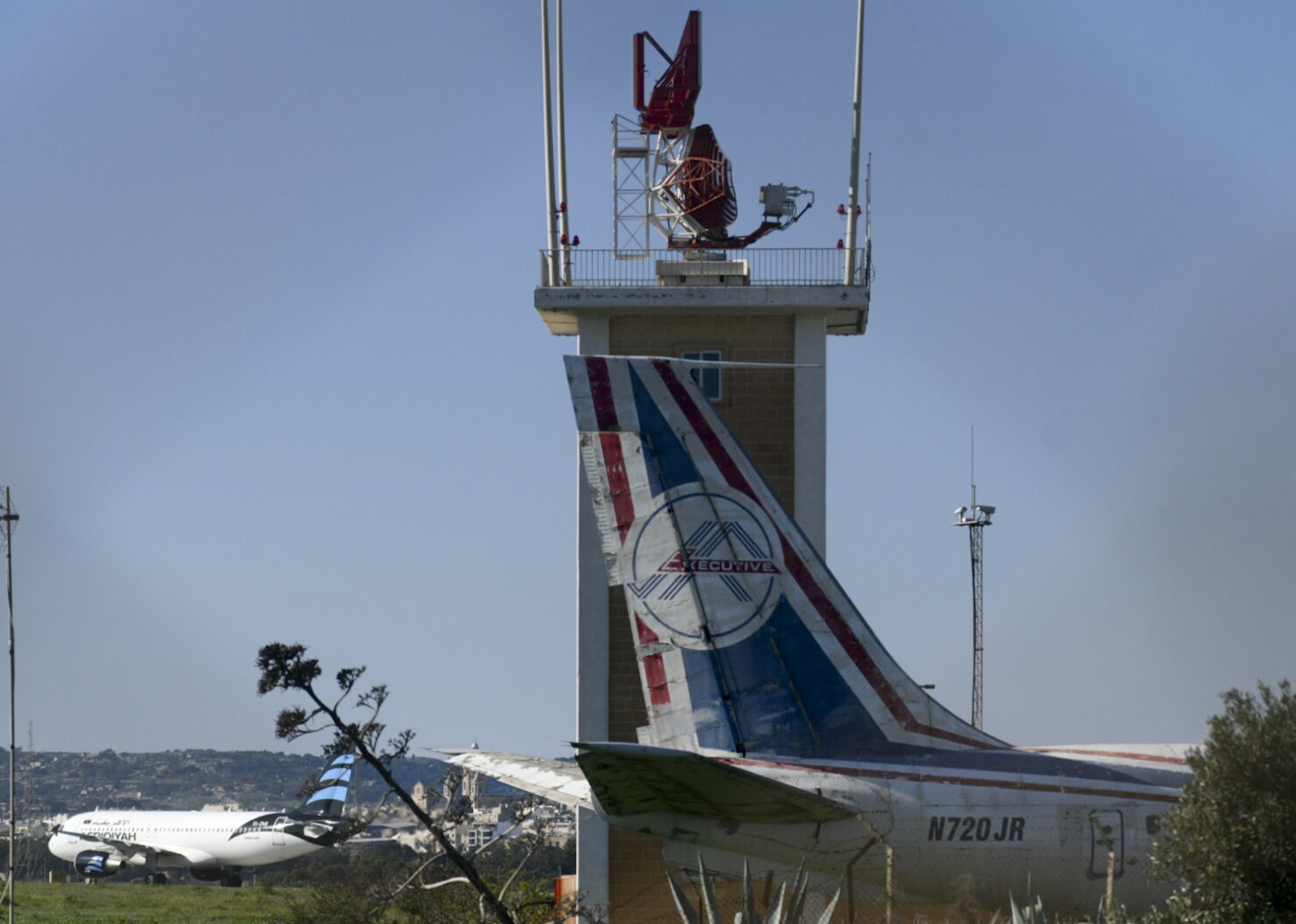 An Afriqiyah Airways plane from Libya, left, stands on the tarmac at Malta's Luqa International airport, Friday, Dec. 23, 2016. Malta's state television says two hijackers who diverted a Libyan commercial plane to the Mediterranean island nation have threatened to blow it up. (AP Photo/Jonathan Borg)