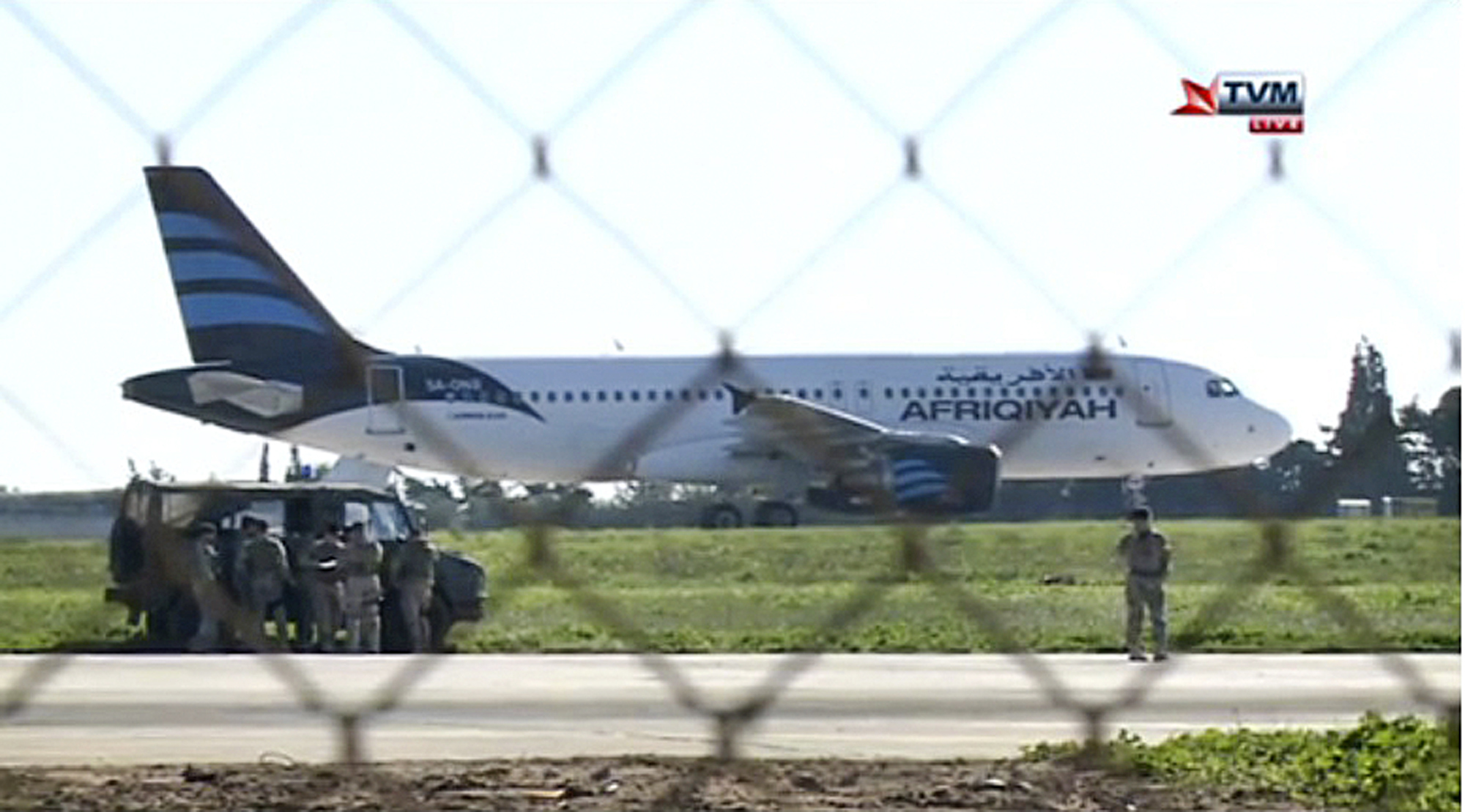 In this frame grab taken from television a hijacked Afriqiyah Airways A320 sits on the tarmac at Malta International airport Friday Dec. 23, 2016. Malta's state television says two hijackers who diverted a Libyan commercial plane to the Mediterranean island nation have threatened to blow it up. (Photo TVM via AP)