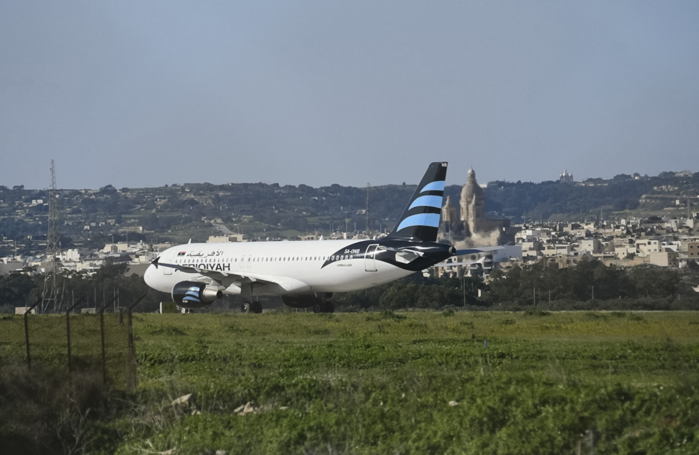 An Afriqiyah Airways plane from Libya stands on the tarmac at Malta's Luqa International airport, Friday, Dec. 23, 2016. Malta's state television says two hijackers who diverted a Libyan commercial plane to the Mediterranean island nation have threatened to blow it up. (AP Photo/Jonathan Borg)