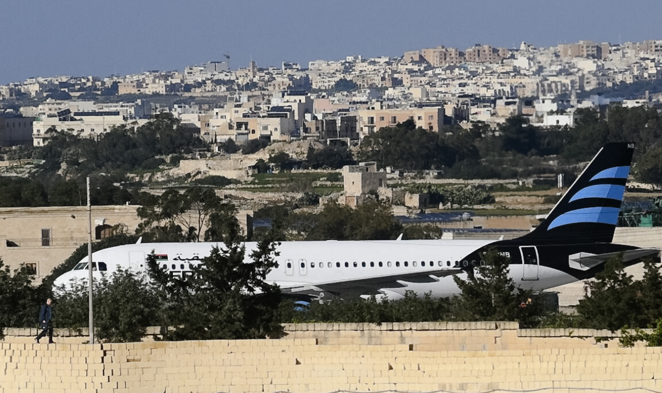 An Afriqiyah Airways plane from Libya stands on the tarmac at Malta's Luqa International airport, Friday, Dec. 23, 2016. Two hijackers diverted a Libyan commercial plane to Malta on Friday and threatened to blow it up with hand grenades, Maltese authorities and state media said.  (AP Photo/Jonathan Borg)
