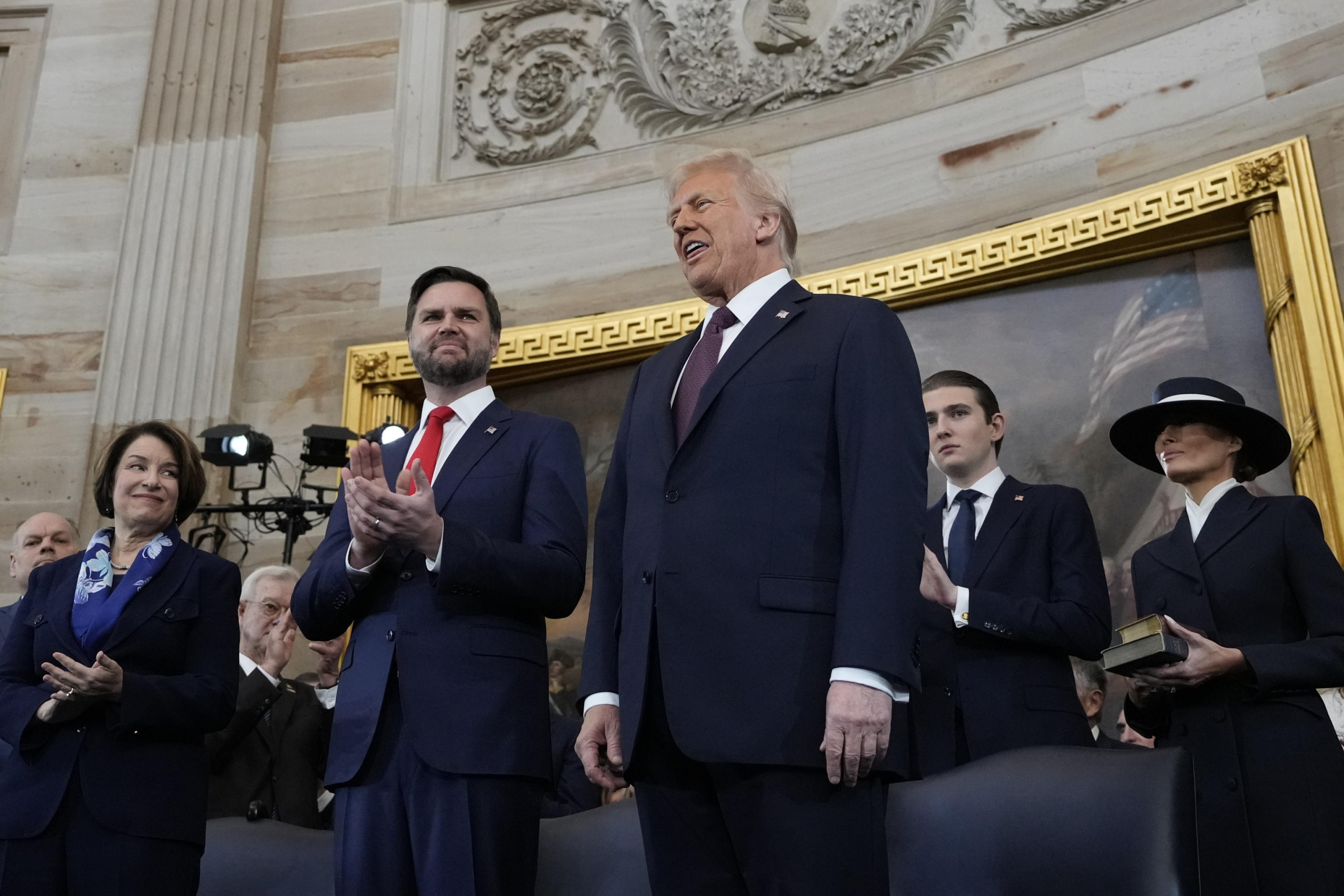 epa11839064 Donald Trump, right, and JD Vance, left, on stage before taking their oaths of office during the Inauguration ceremonies in the Rotunda of the U.S. Capitol in Washington on Monday, Jan. 20, 2025.  EPA/Morry Gash / POOL