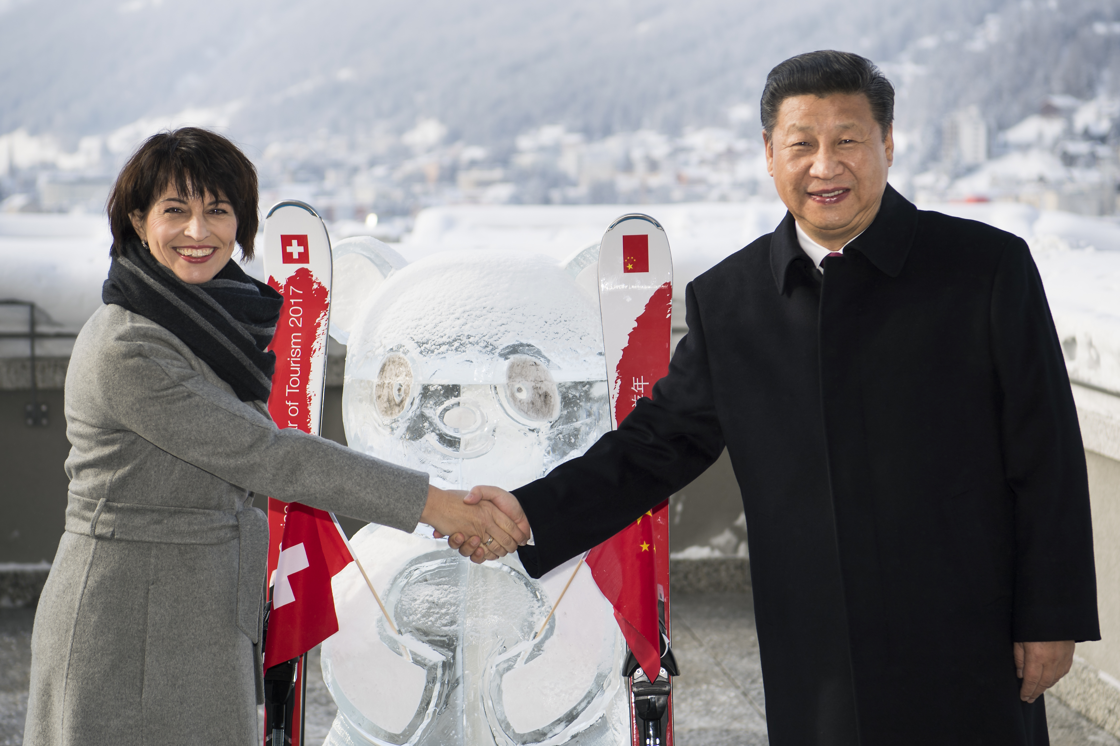 Swiss Federal President Doris Leuthard, left, shakes hands with China's President Xi Jinping, right, as they launch the Swiss-Sino year of tourism next to a panda ice sculpture on the side line of the 47th annual meeting of the World Economic Forum, WEF, in Davos, Switzerland, Tuesday, Jan. 17, 2017. (Laurent Gillieron/pool photo via AP)
