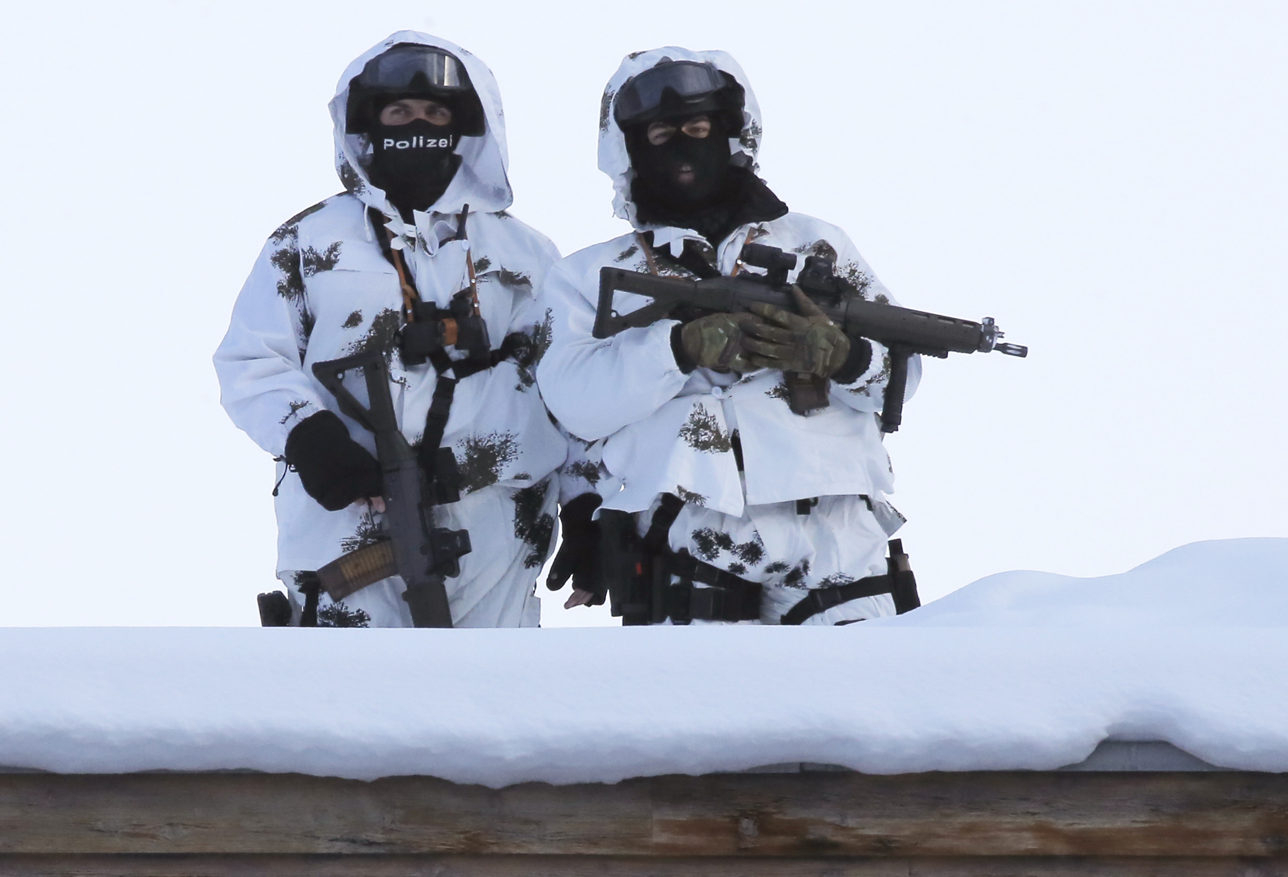 Two armed Swiss police officers stand on a roof top during the 'World Economic Forum' in Davos, Switzerland, Tuesday, Jan. 17, 2017. Business and world leaders are gathering for the annual meeting 'World Economic Forum ' in Davos. (AP Photo/Michel Euler)