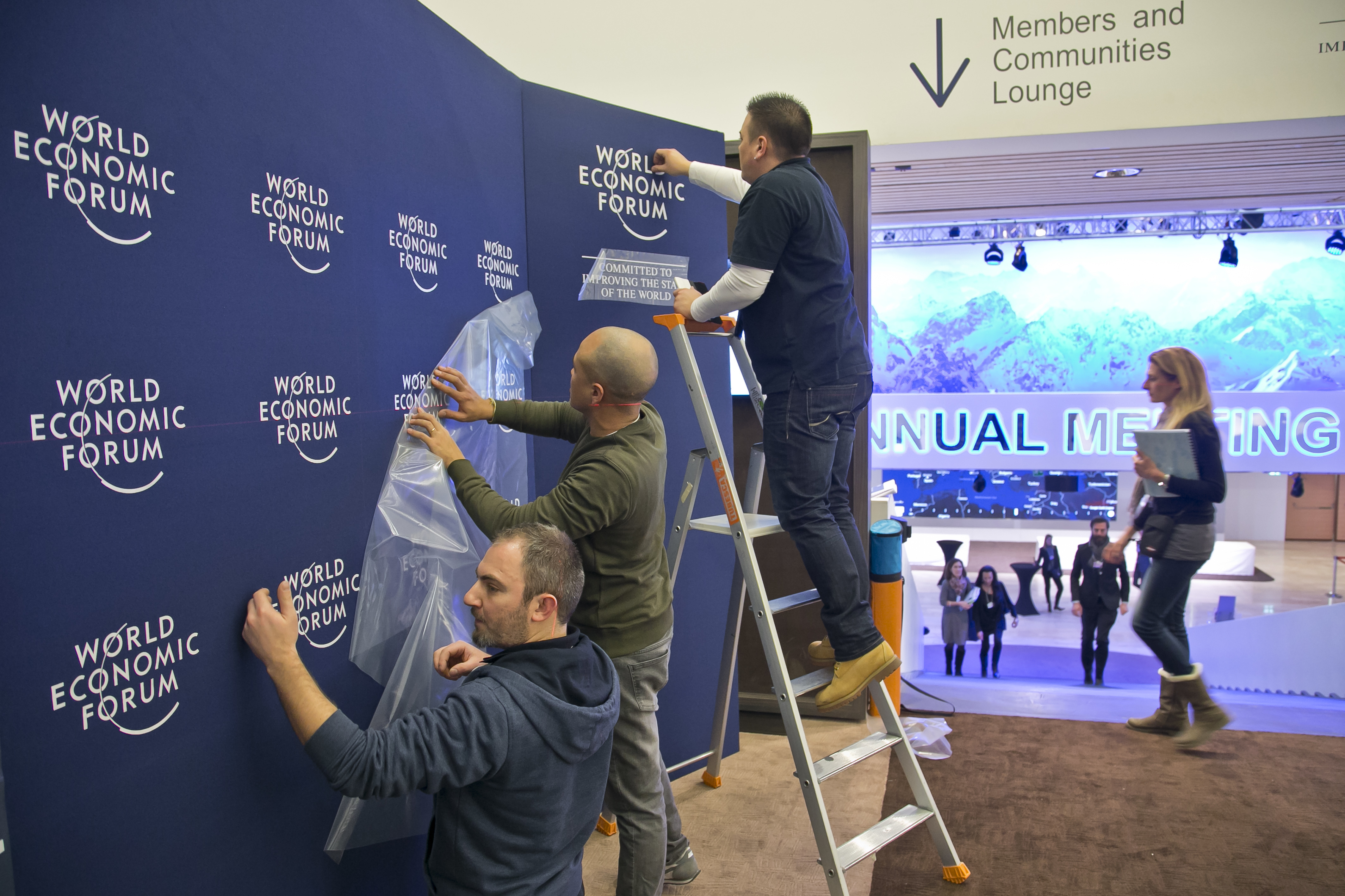 Staff members put up logos of the World Economic Forum at the Congress Center in Davos, Switzerland, Monday, Jan. 16, 2017. Business and world leaders are gathering for the annual meeting World Economic Forum in Davos. (AP Photo/Michel Euler)