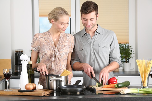 Una donna e un uomo preparano il pranzo in cucina. Foto di Werner Heiber da Pixabay.