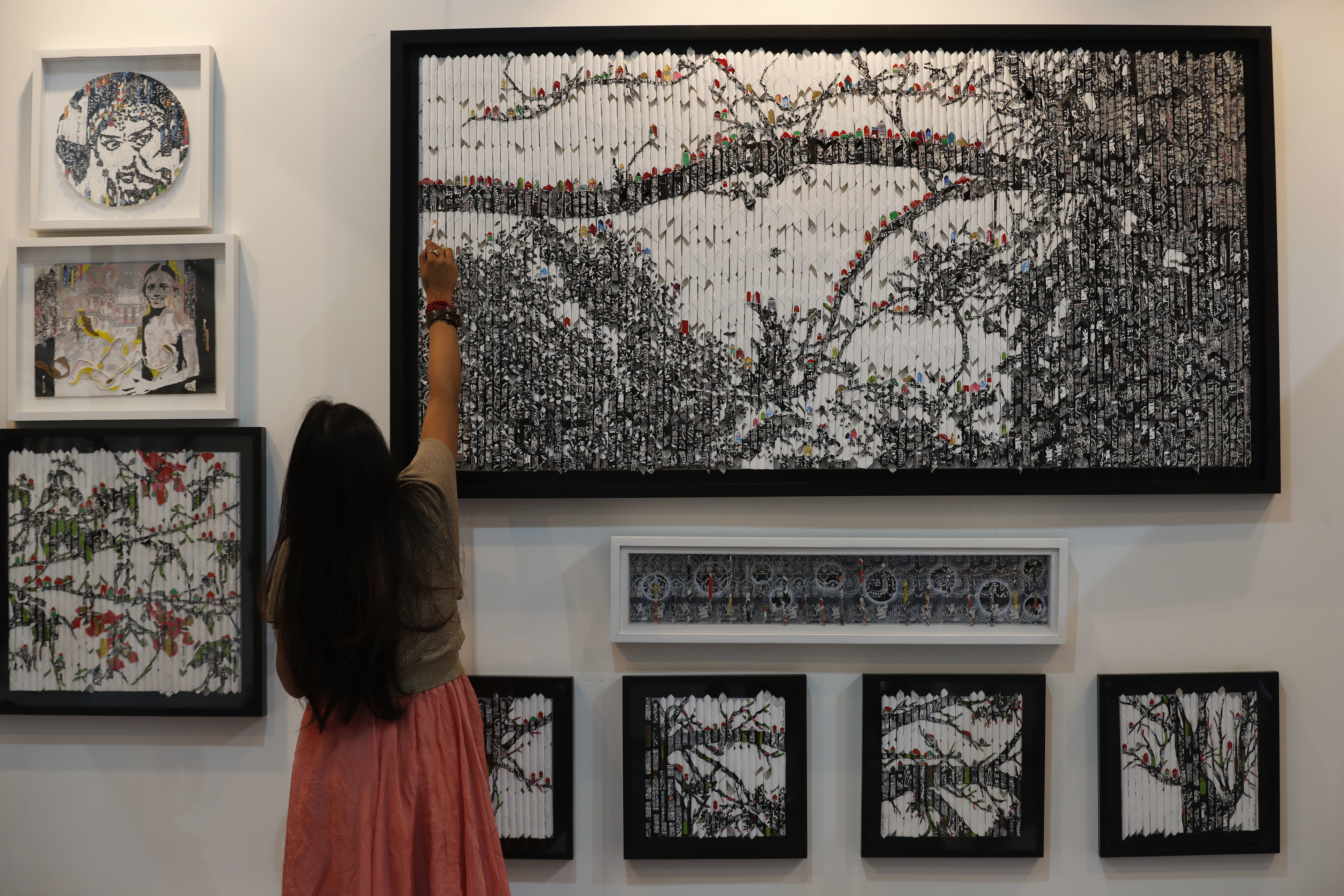 Vinila Dasgupta retouches her art during India Art Fair in New Delhi, India, Thursday, Feb. 2, 2017. The four day art fair brings together a number of modern and contemporary artists to present their works. (AP Photo/Tsering Topgyal)