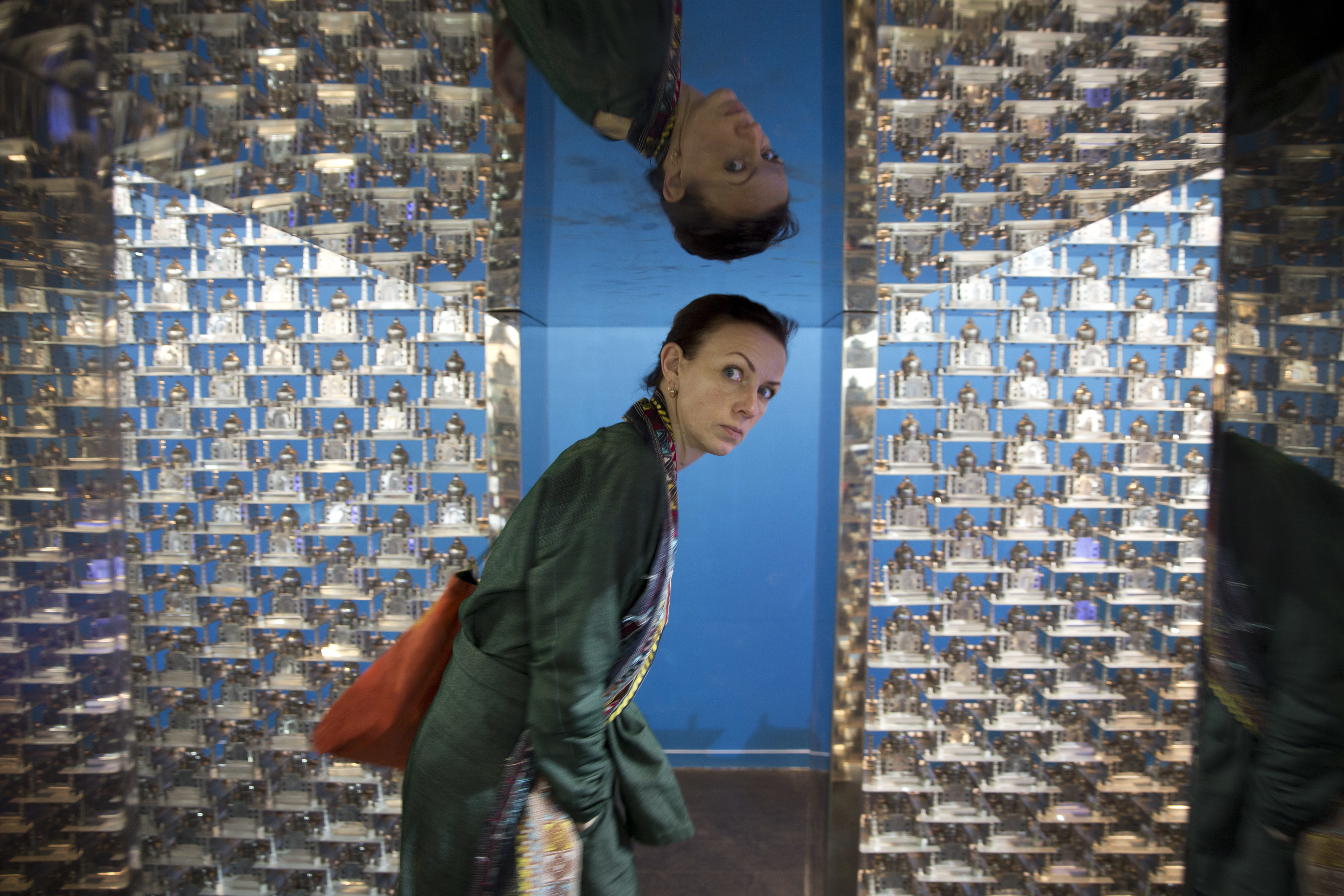 A woman looks inside an art installation titled Taj by Sudarshan Shetty during the India Art Fair in New Delhi, India, Thursday, Feb. 2, 2017. The four day art fair brings together a number of modern and contemporary artists to present their works. (AP Photo/Tsering Topgyal)